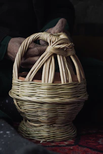 Hands weaving a traditional wicker basket with care