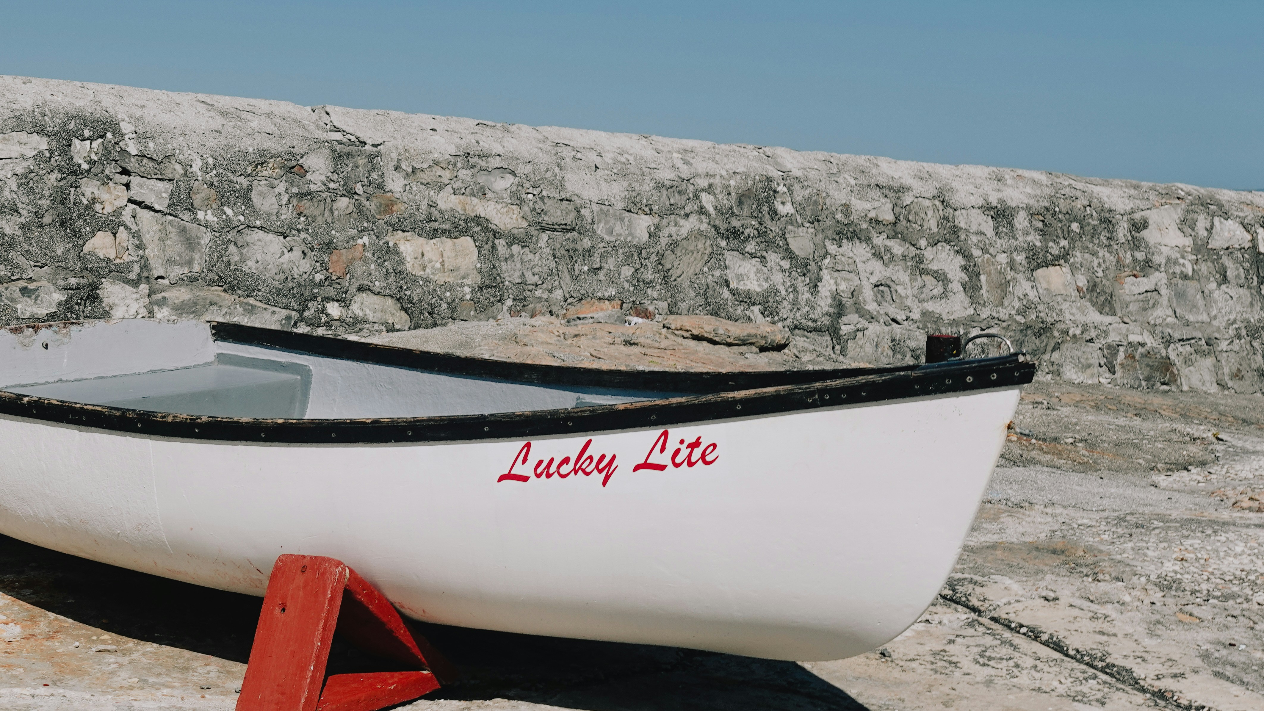 White rowboat with "lucky lite" text on it