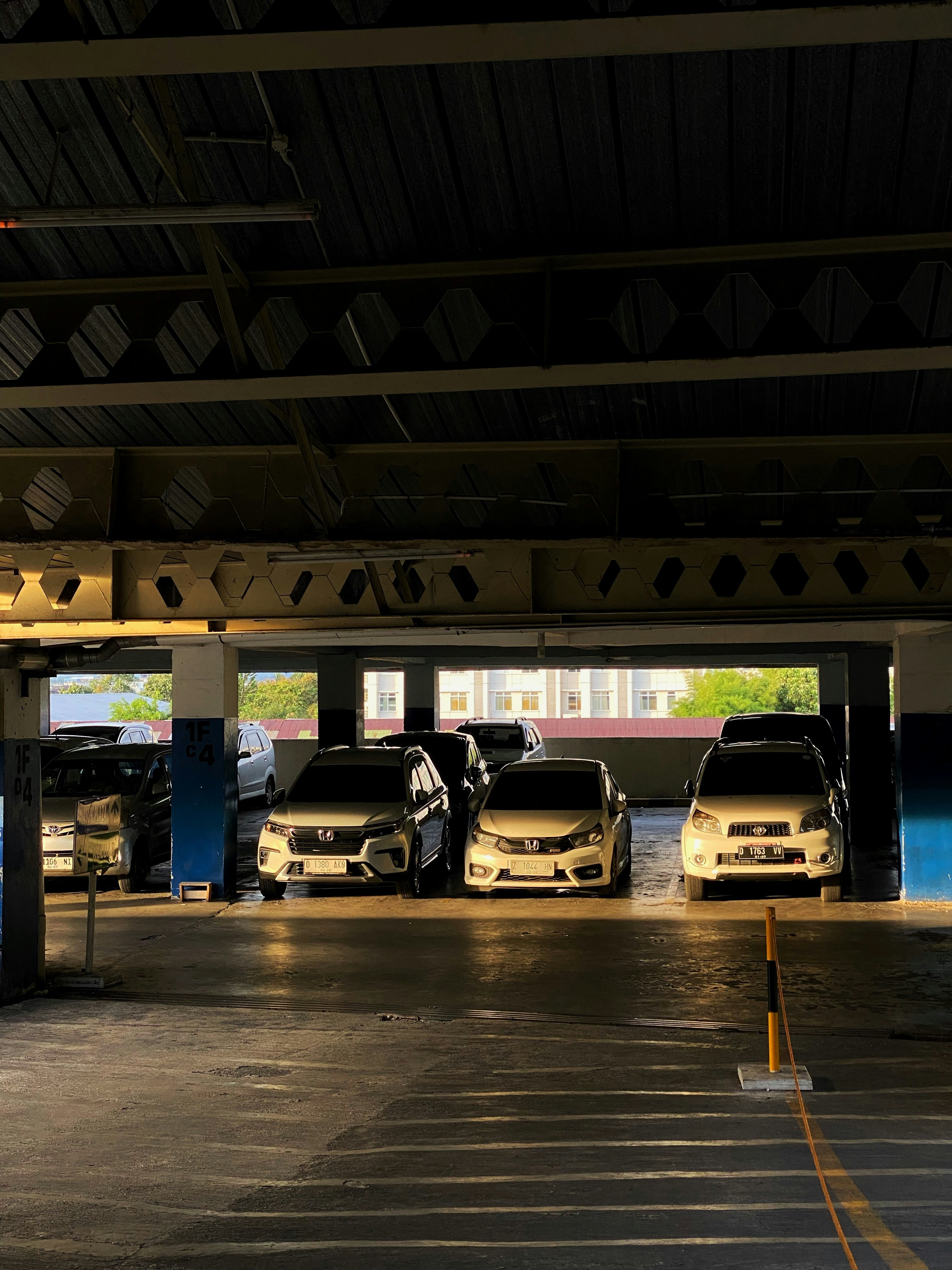 Cars parked in a dimly lit concrete parking garage.