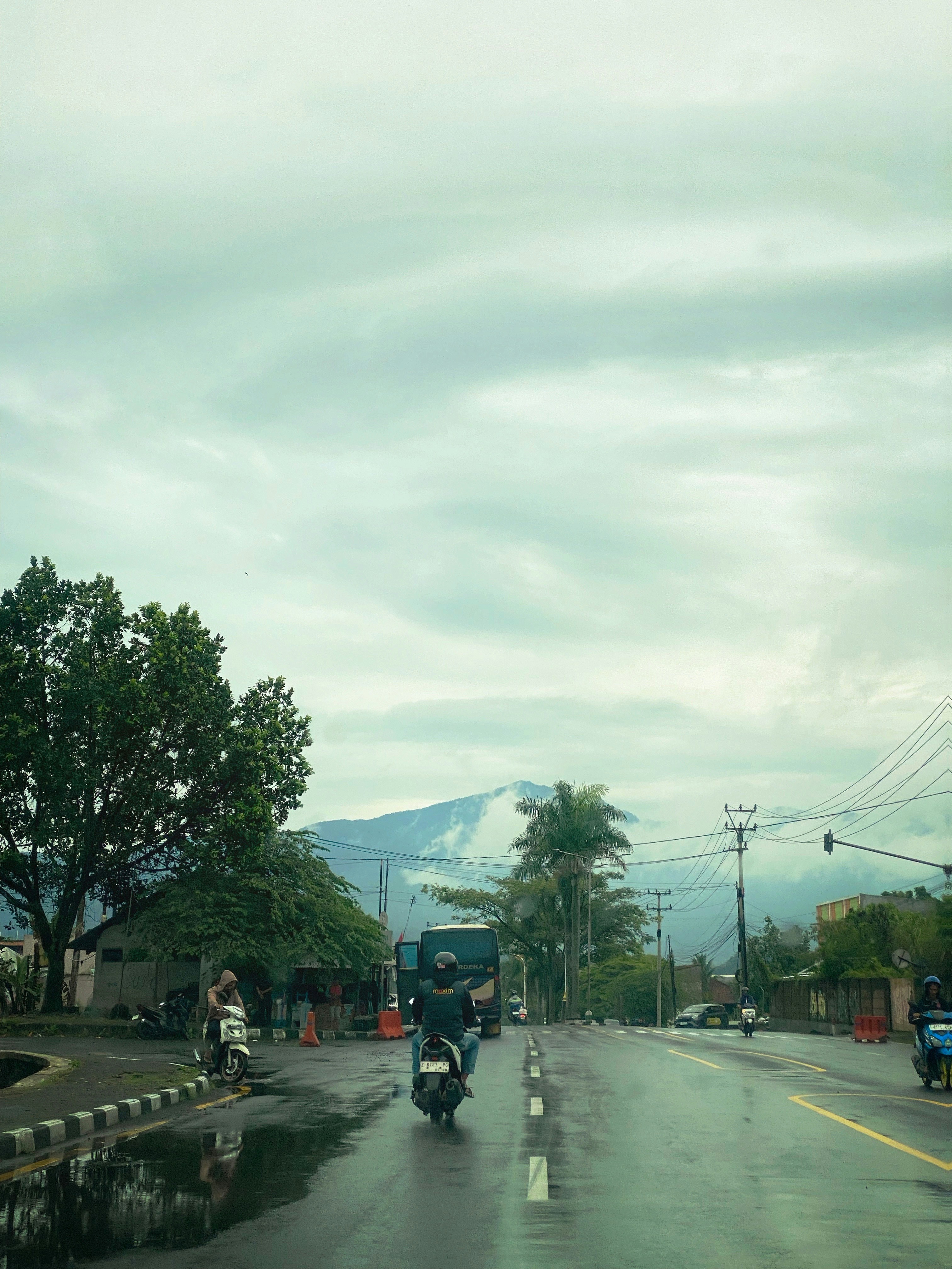 Motorcycles on a wet road with mountains in background