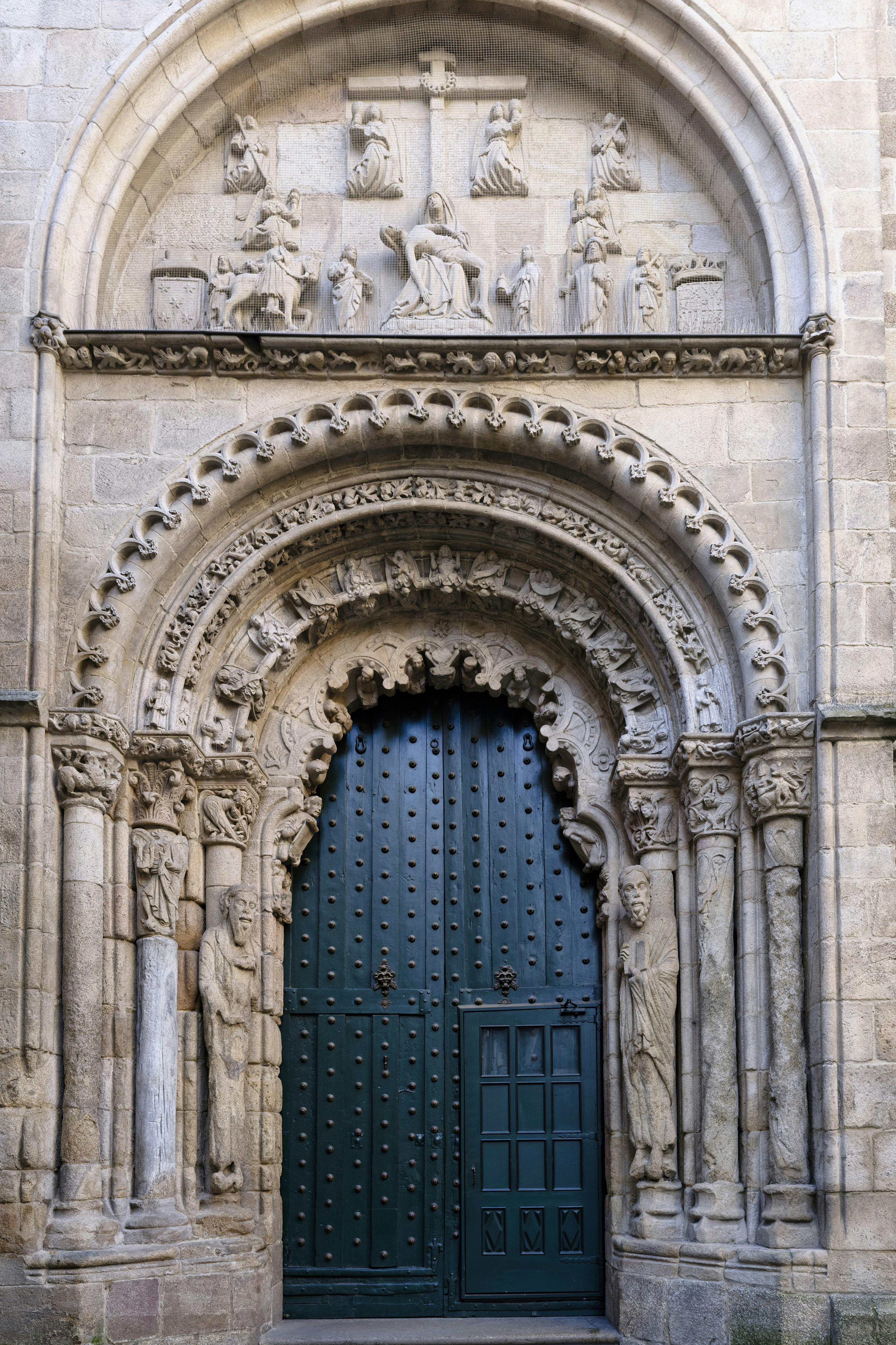 Ornate stone archway with a dark green door
