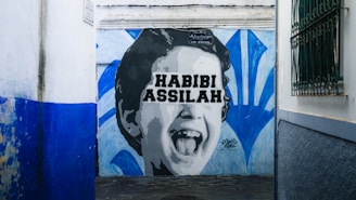 Graffiti of a laughing child with text on a wall.