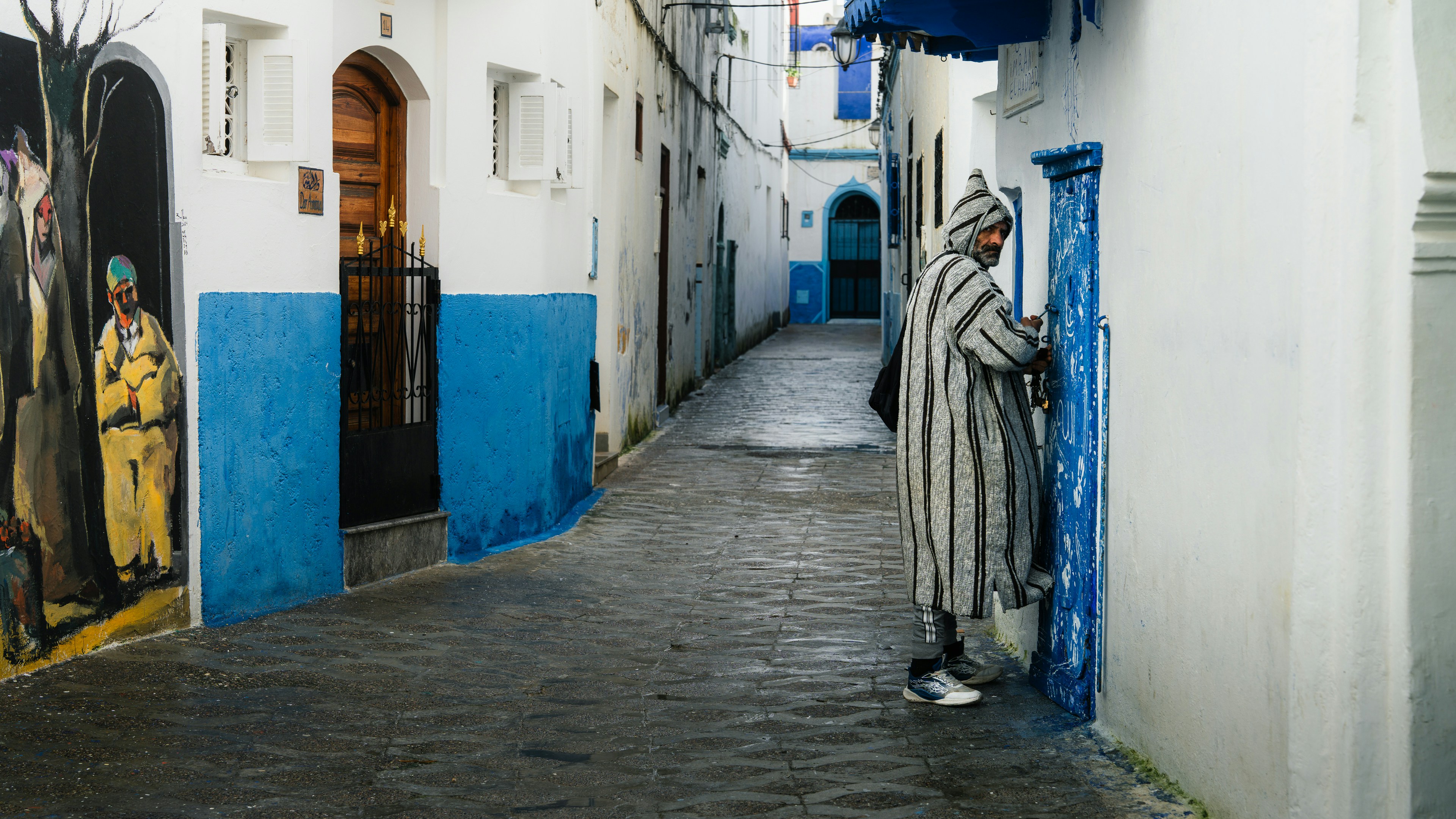 Man in traditional clothing in narrow alleyway