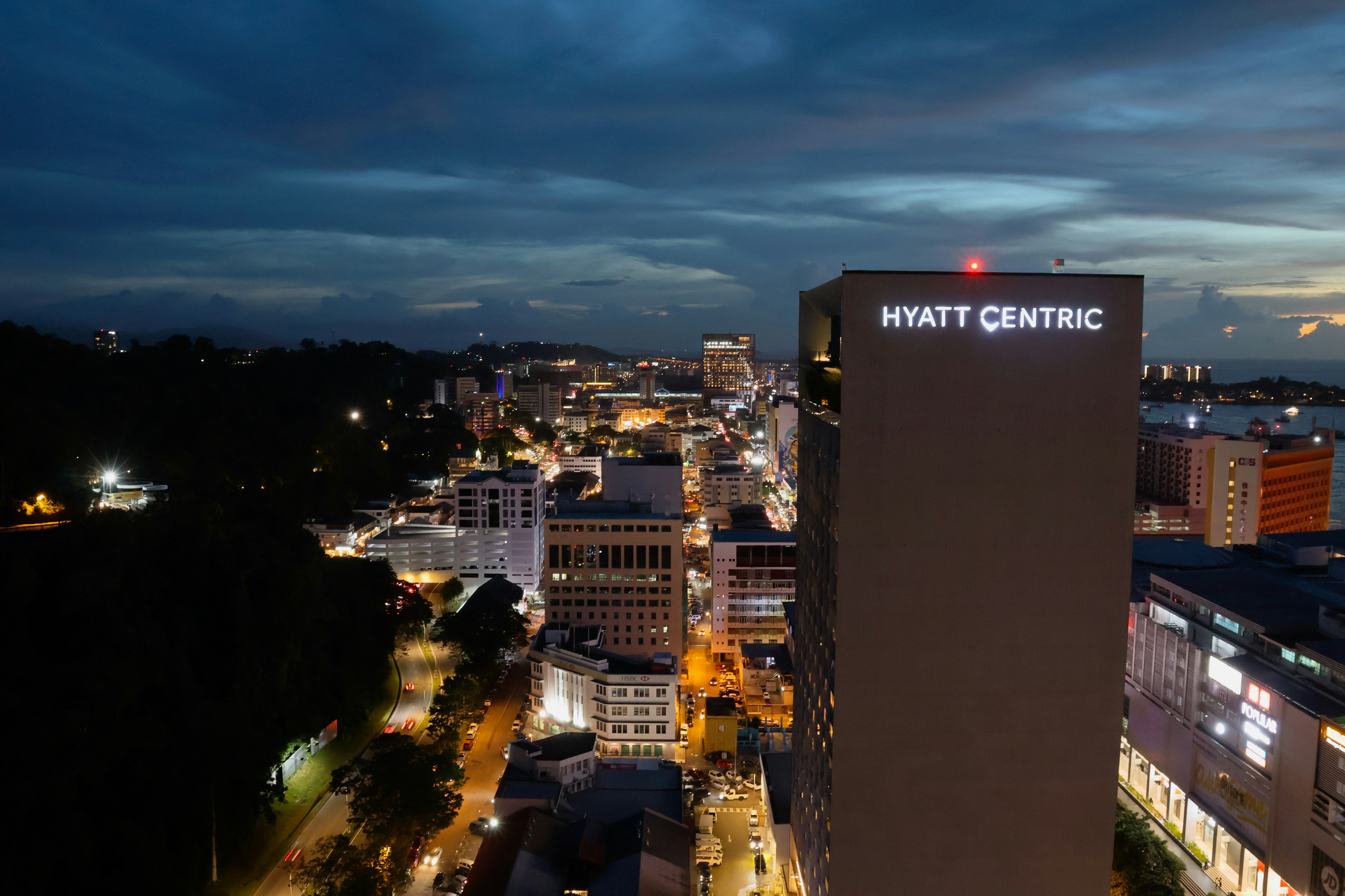 Hyatt centric building overlooking a city at dusk