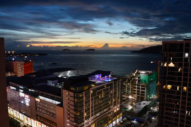 Cityscape and ocean view at dusk with dramatic clouds
