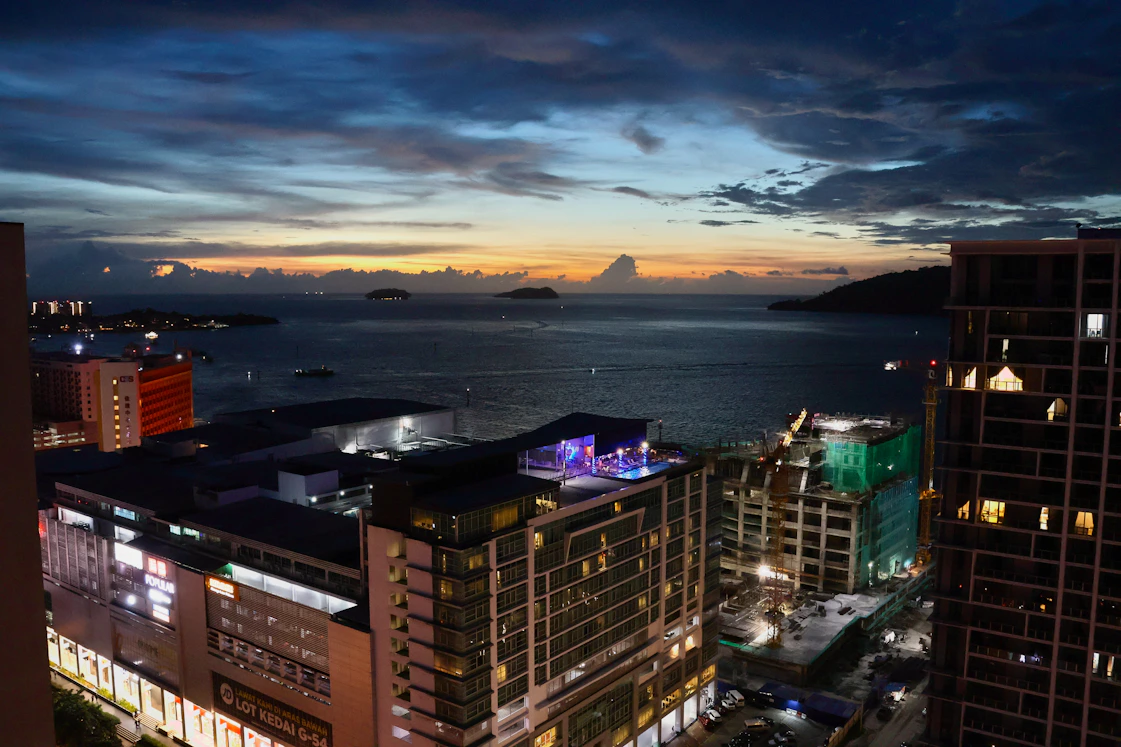Cityscape and ocean view at dusk with dramatic clouds