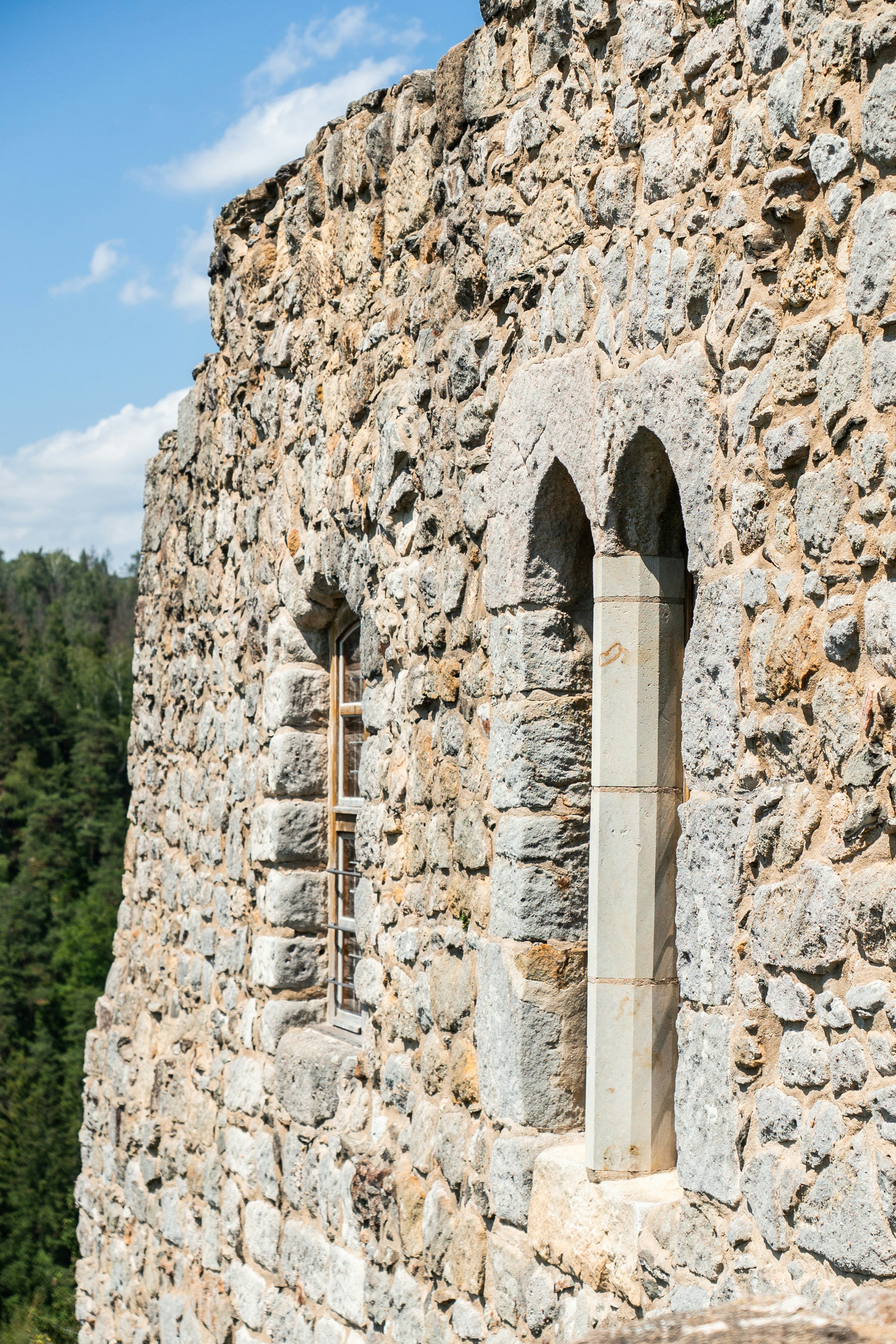 Stone wall of an ancient castle with arched windows