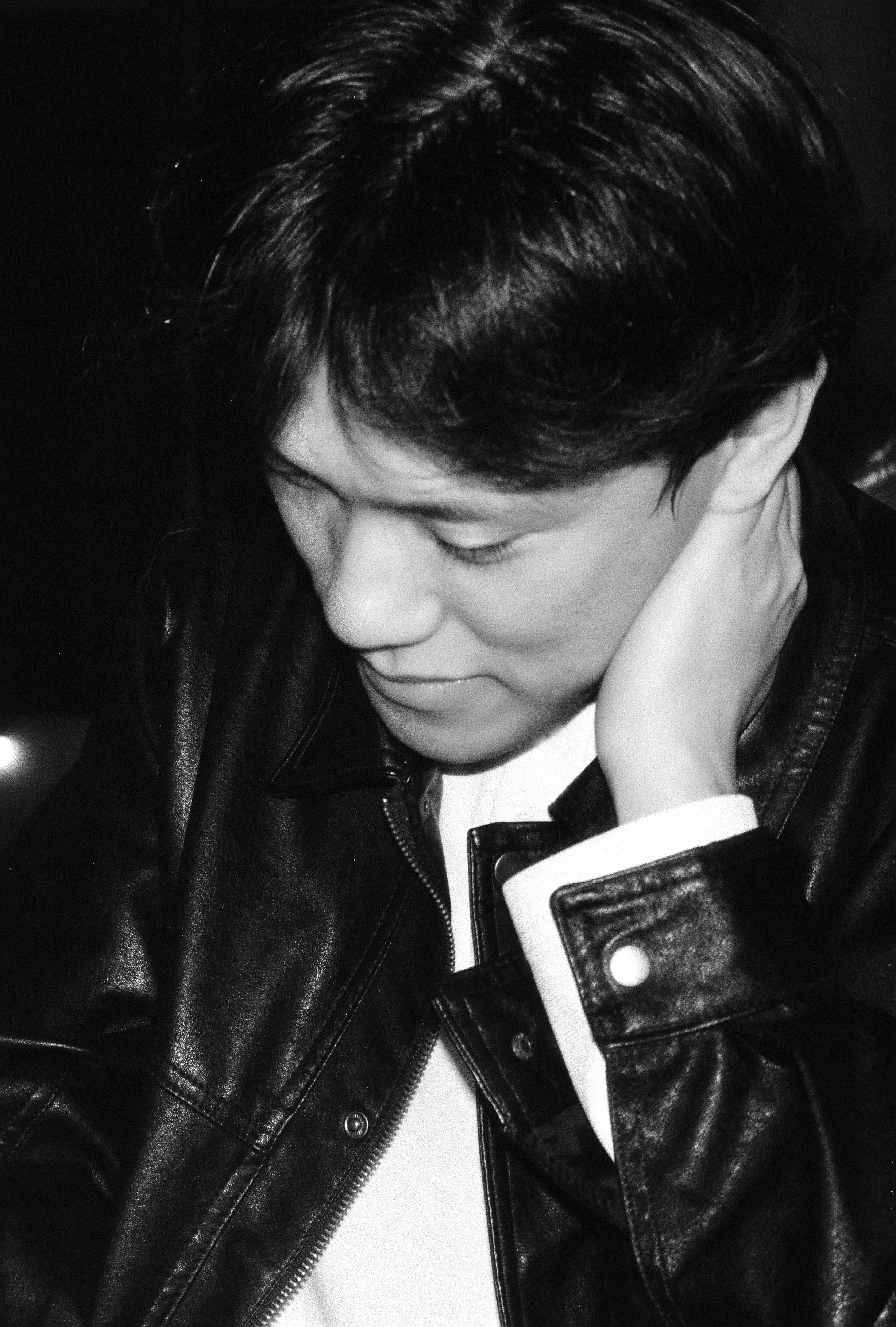 革のジャケットを着た男が下を見下ろしている。