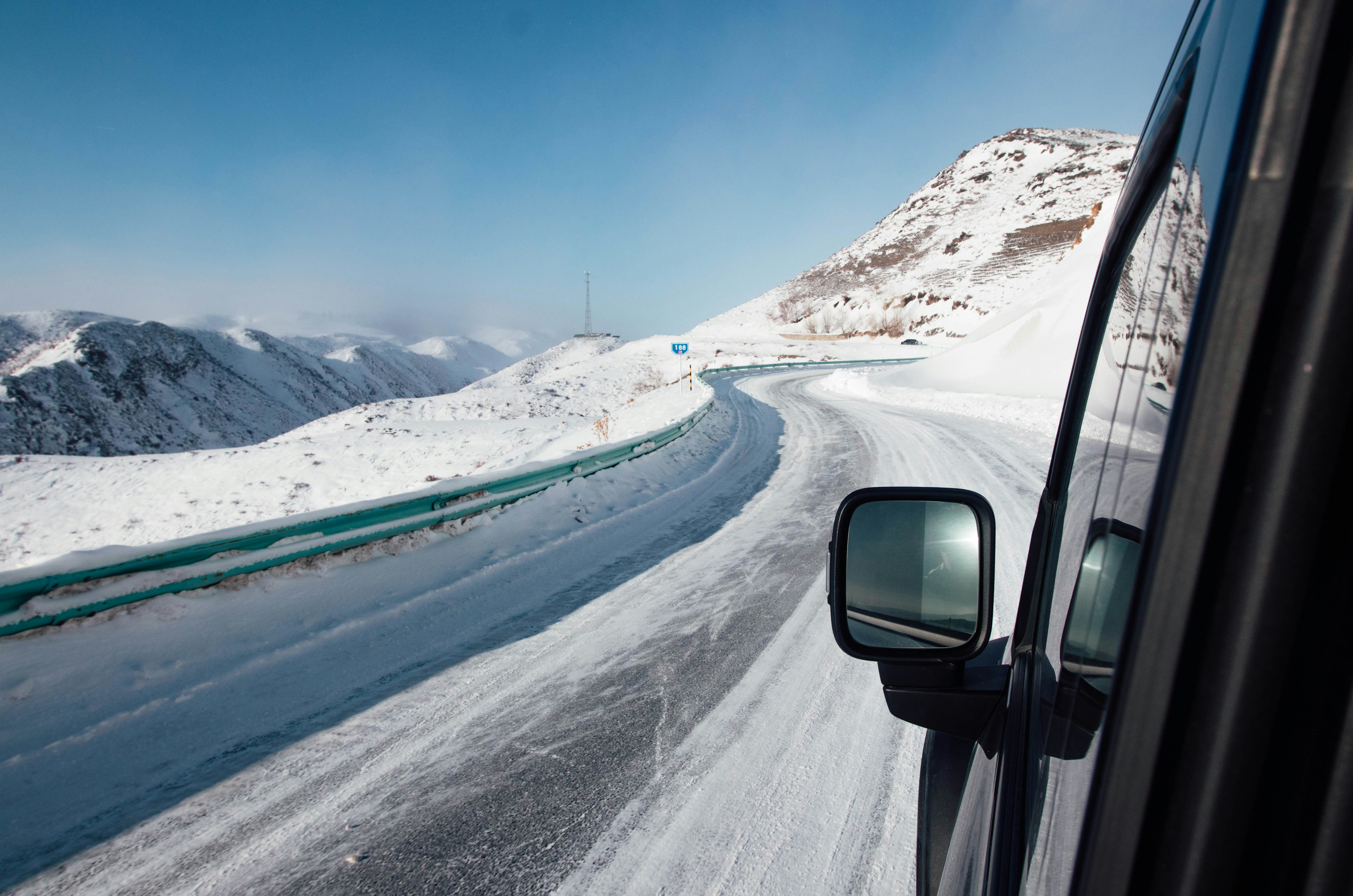 Driving on a snowy mountain road with clear sky