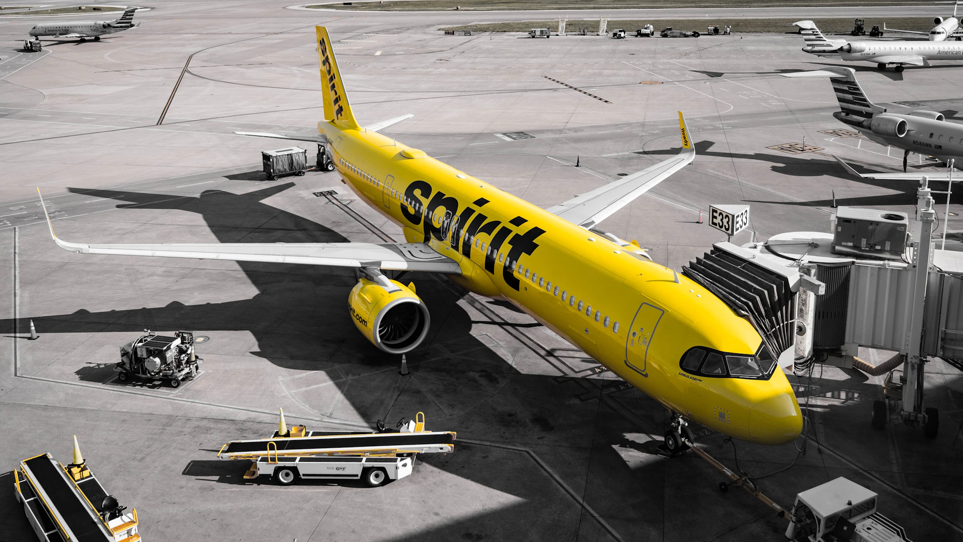 A yellow spirit airlines airplane at the gate.