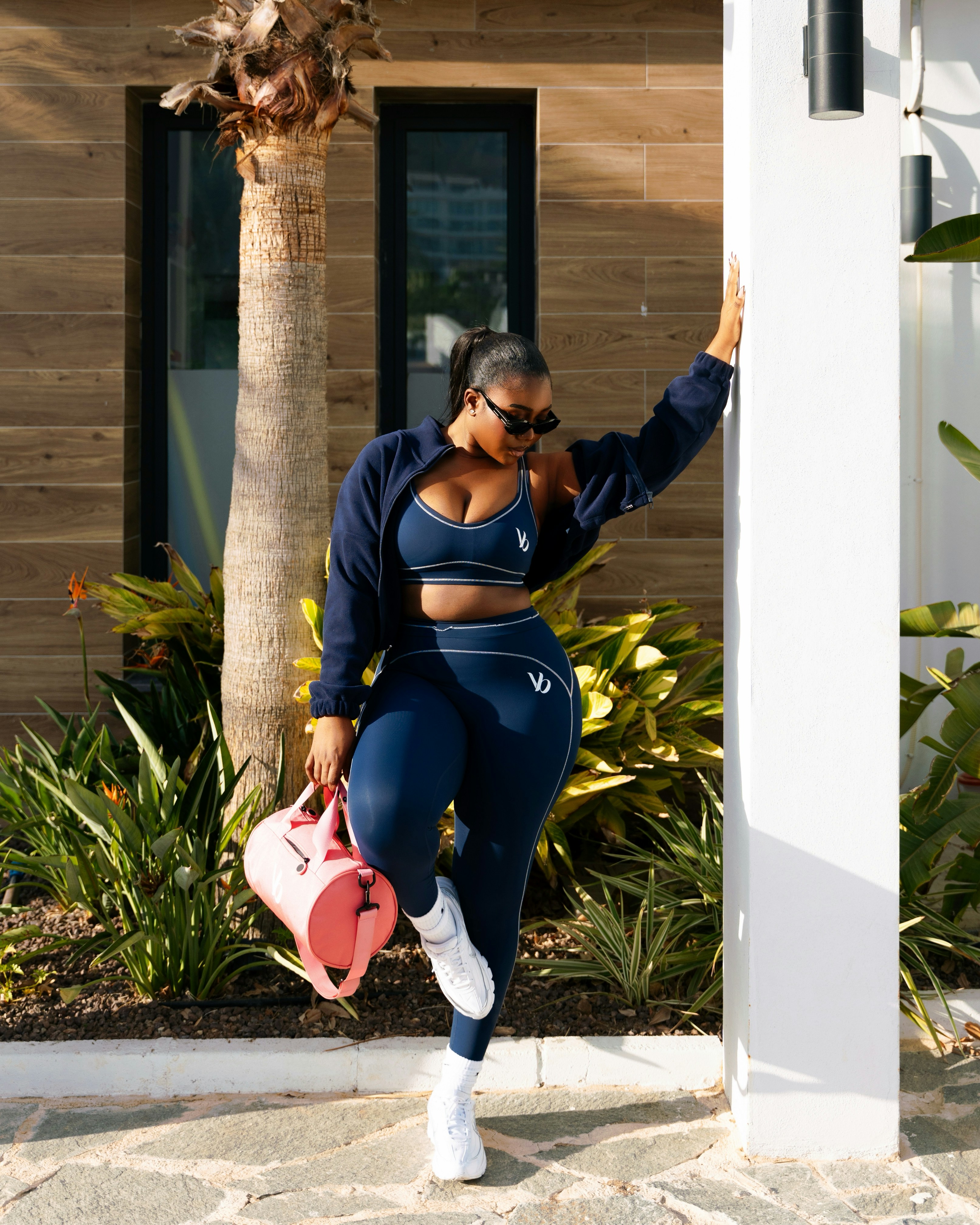 Woman in navy athletic wear with pink bag