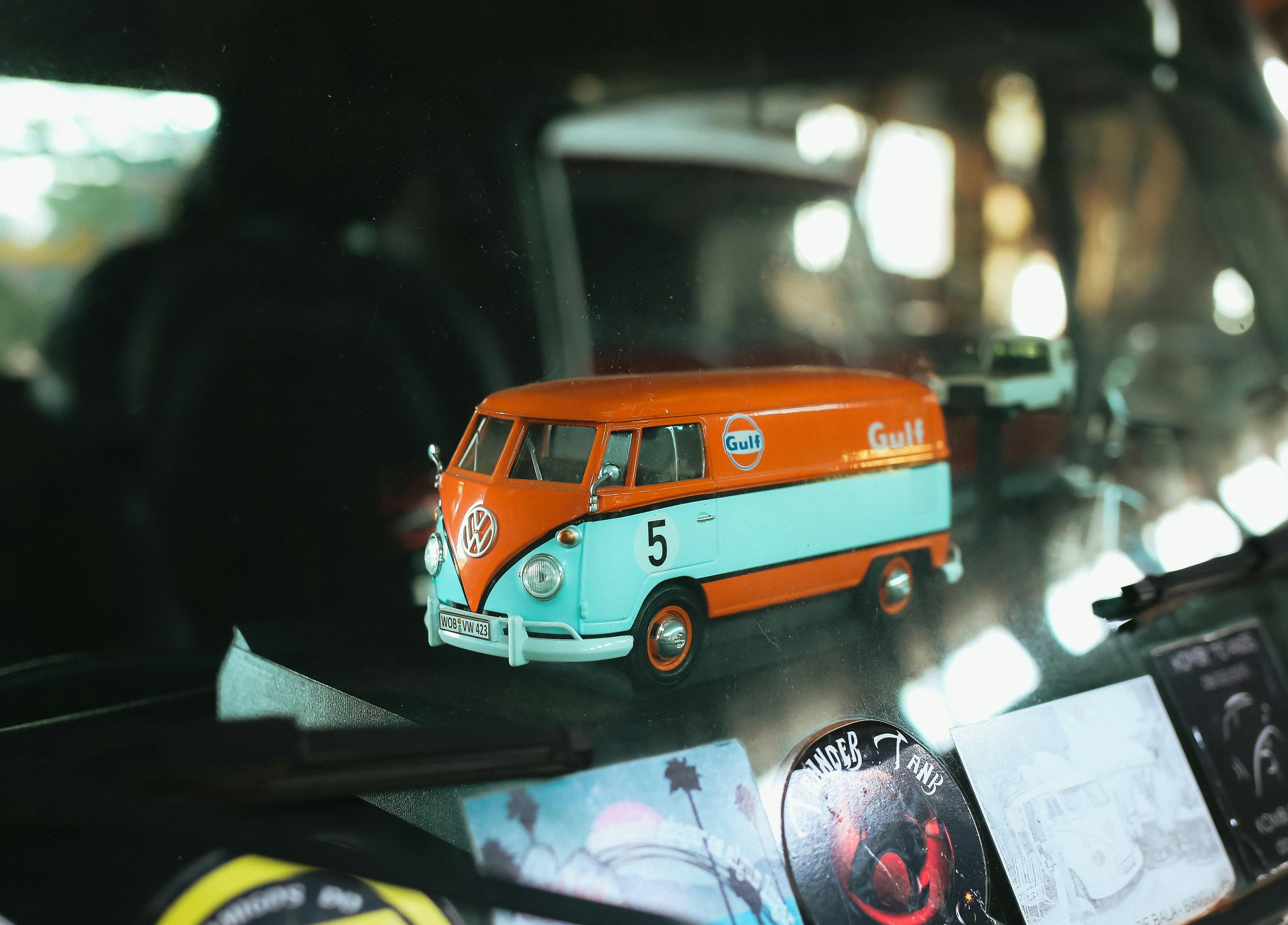 A vintage volkswagen van toy with orange and teal colors.