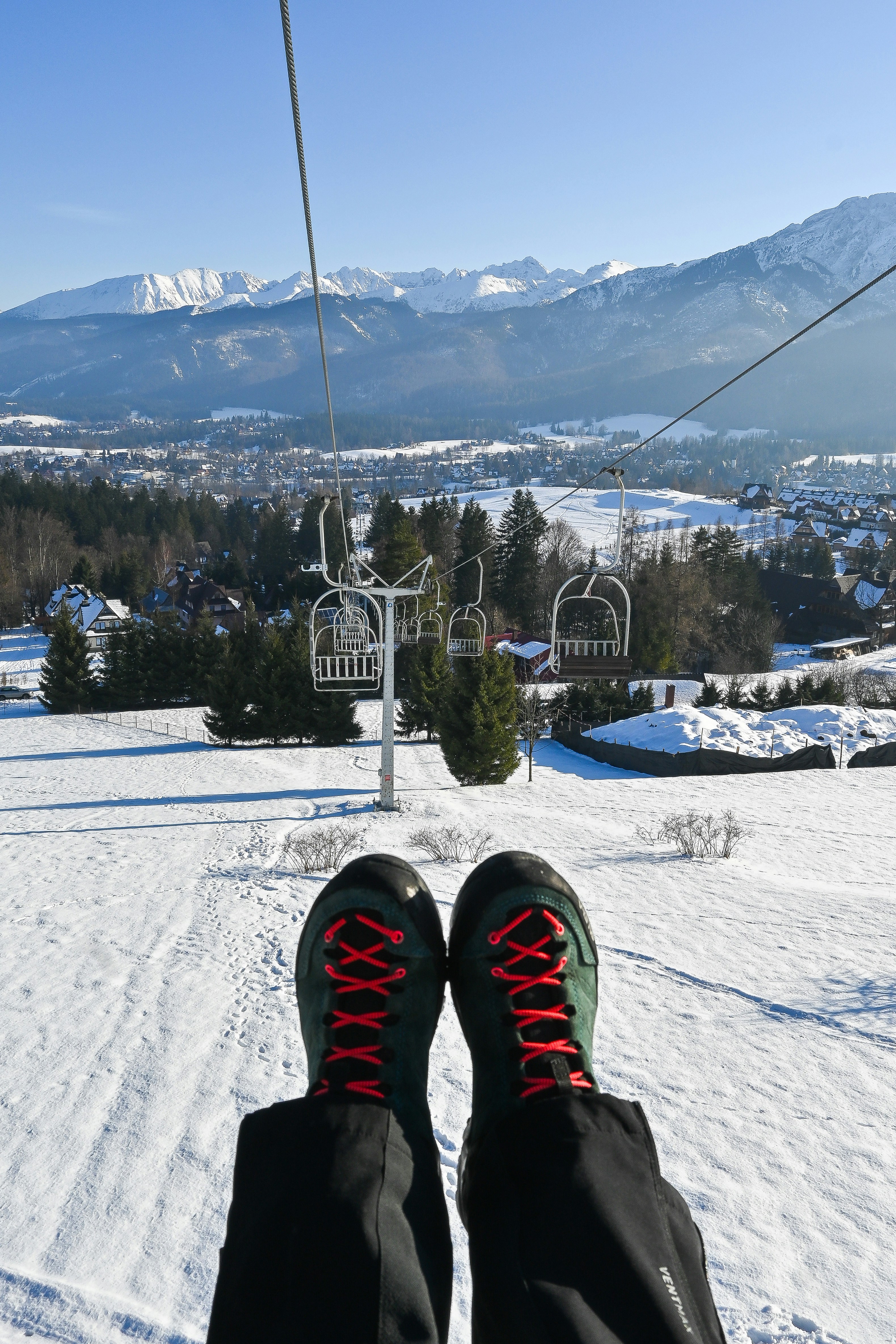 雪山を背景にしたスキーリフトに乗る