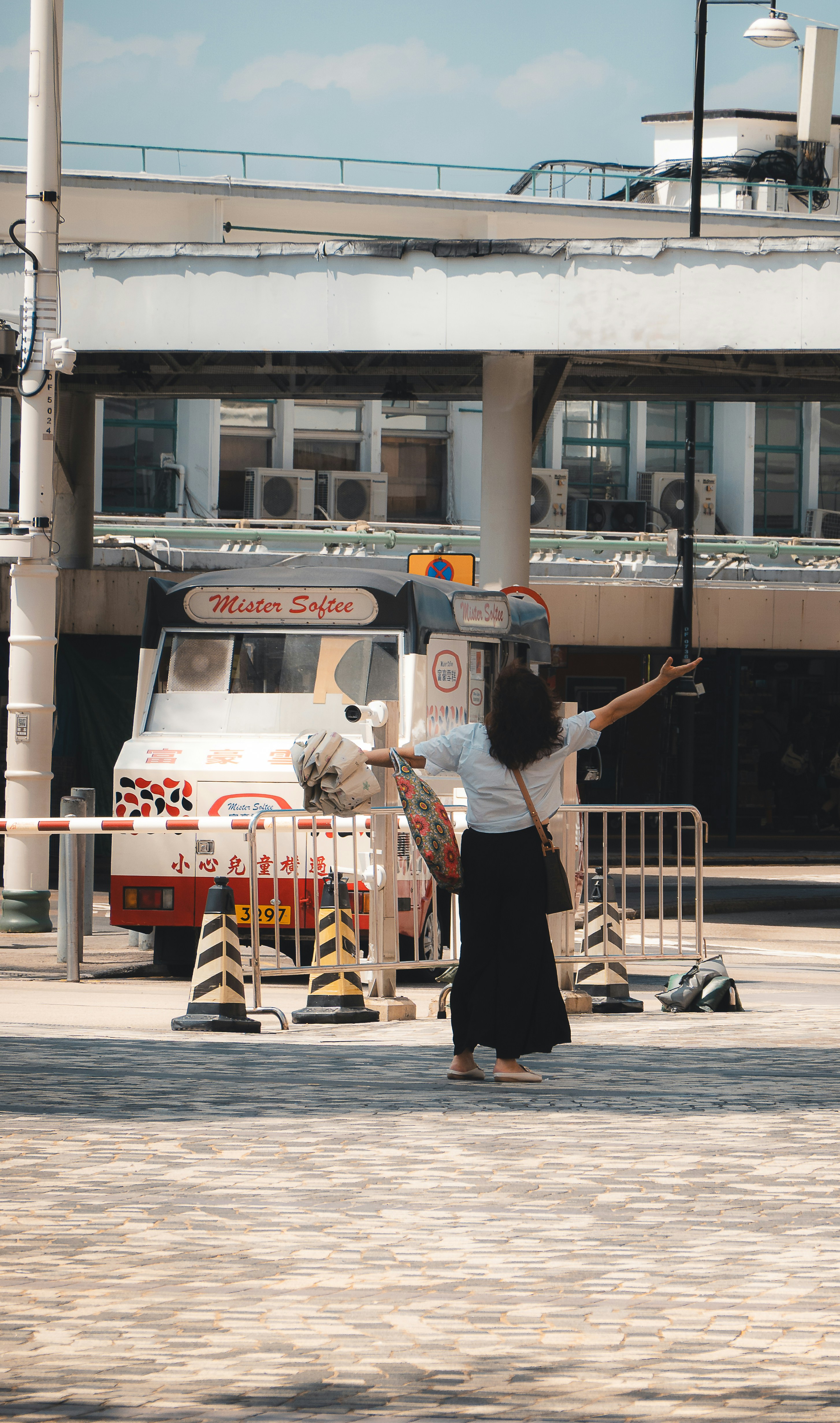 Frau mit ausgestreckten Armen in der Nähe eines Kaffeewagens.