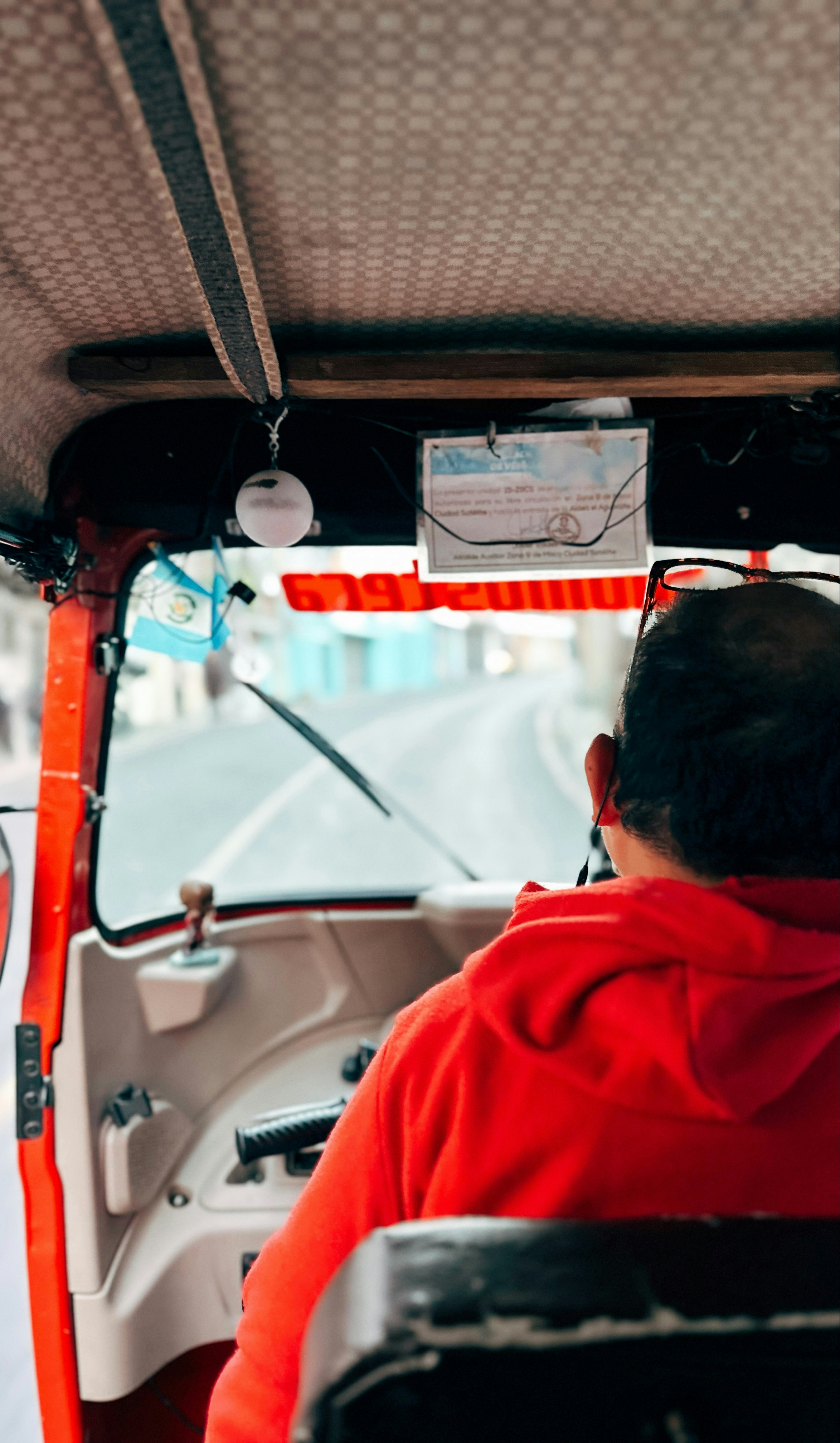 Man in red hoodie driving a tuk-tuk