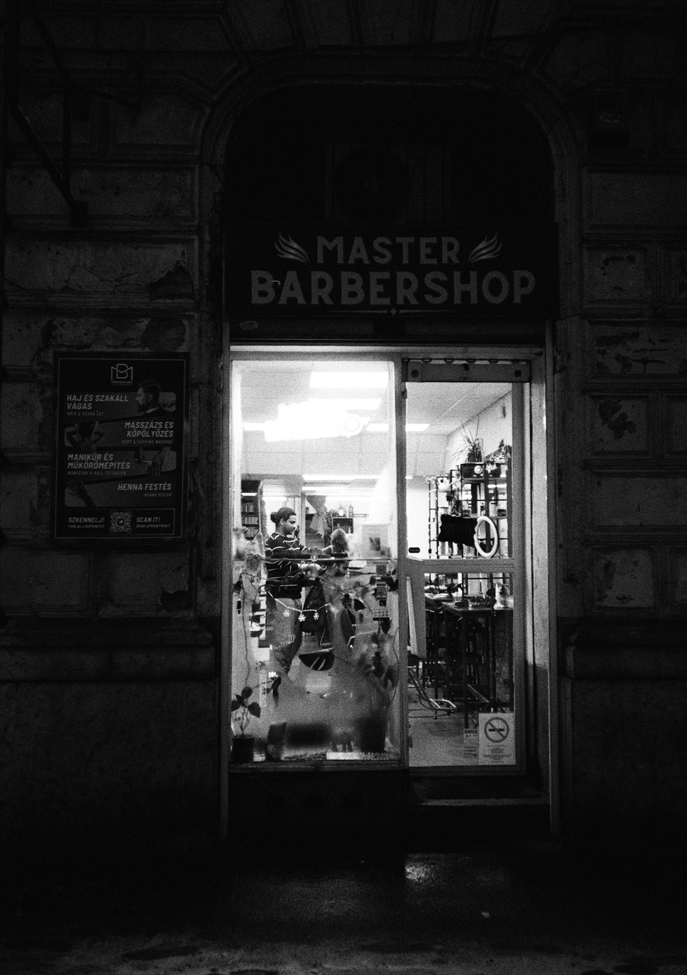 Master-Barbershop-Schaufenster nachts mit eingeschaltetem Licht