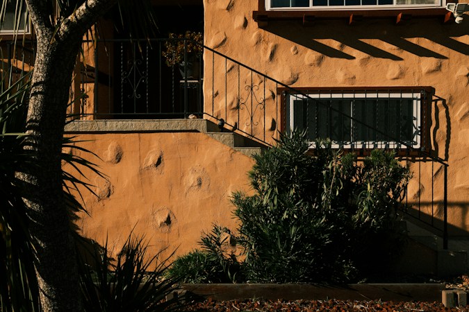 Stucco home exterior with front stairs and potted plants, the style of house common across Las Vegas and Henderson neighborhoods