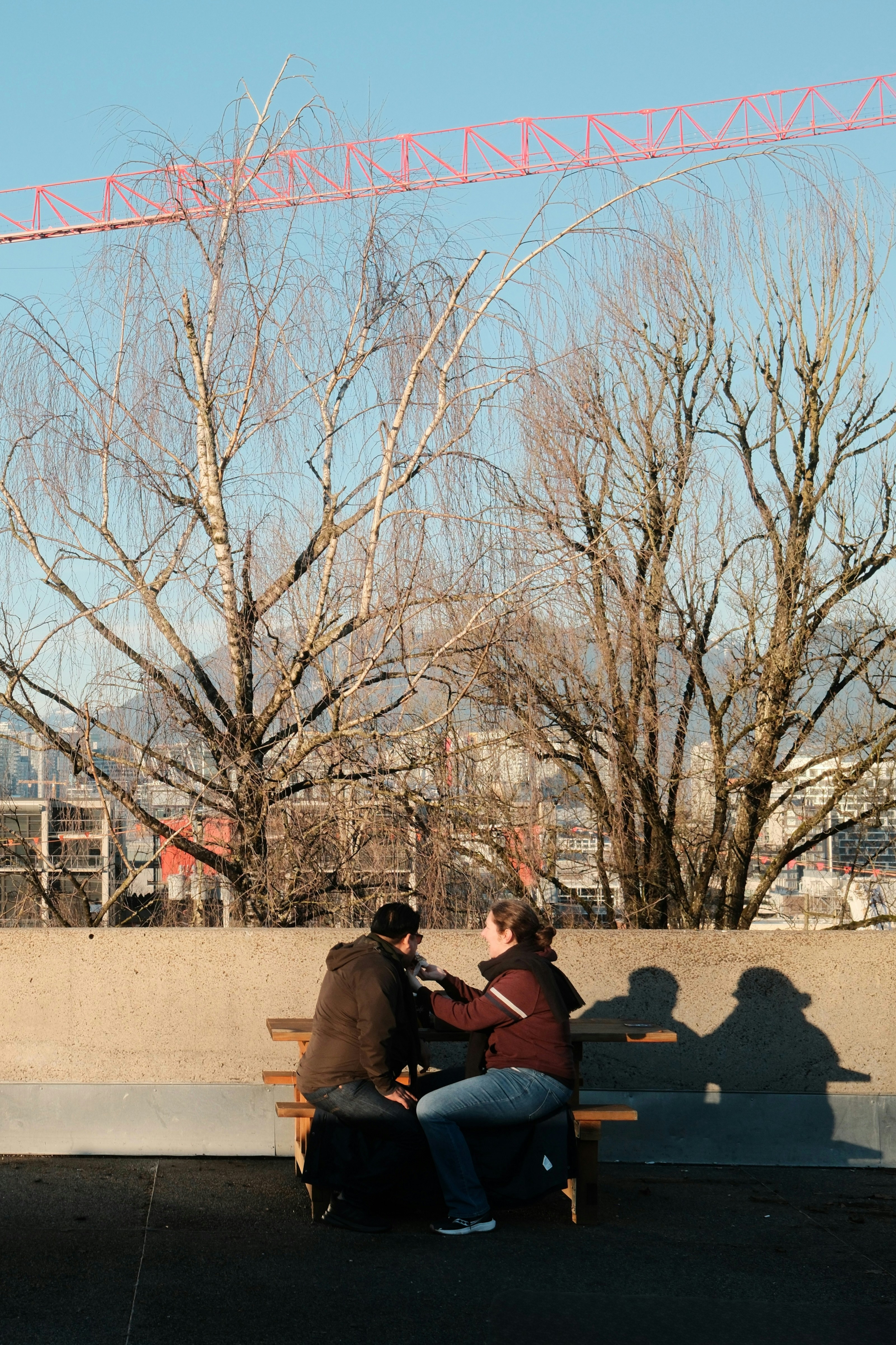 Zwei Personen sitzen draußen auf einer Bank