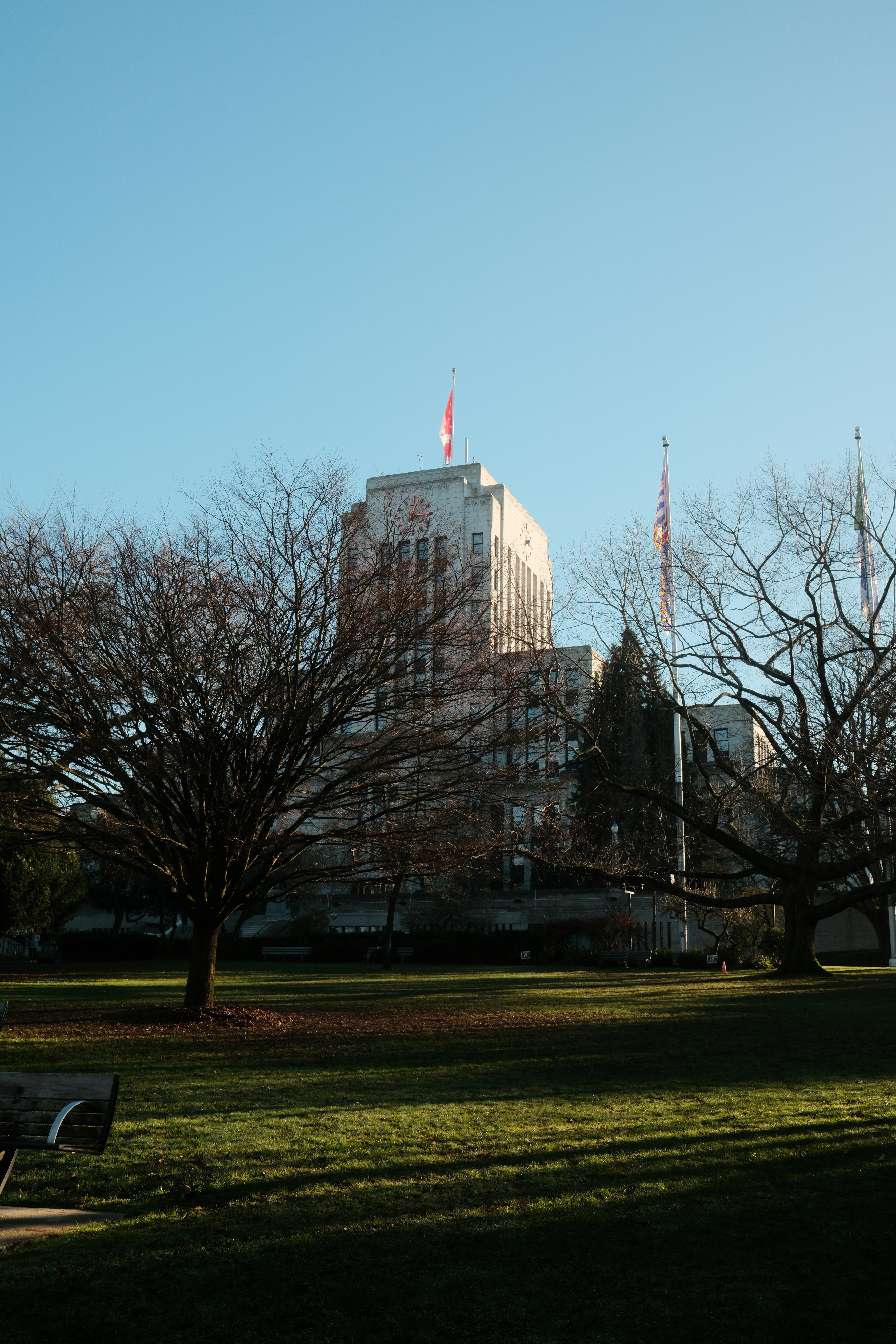 Hoches Gebäude mit Fahnen vor klarem blauen Himmel