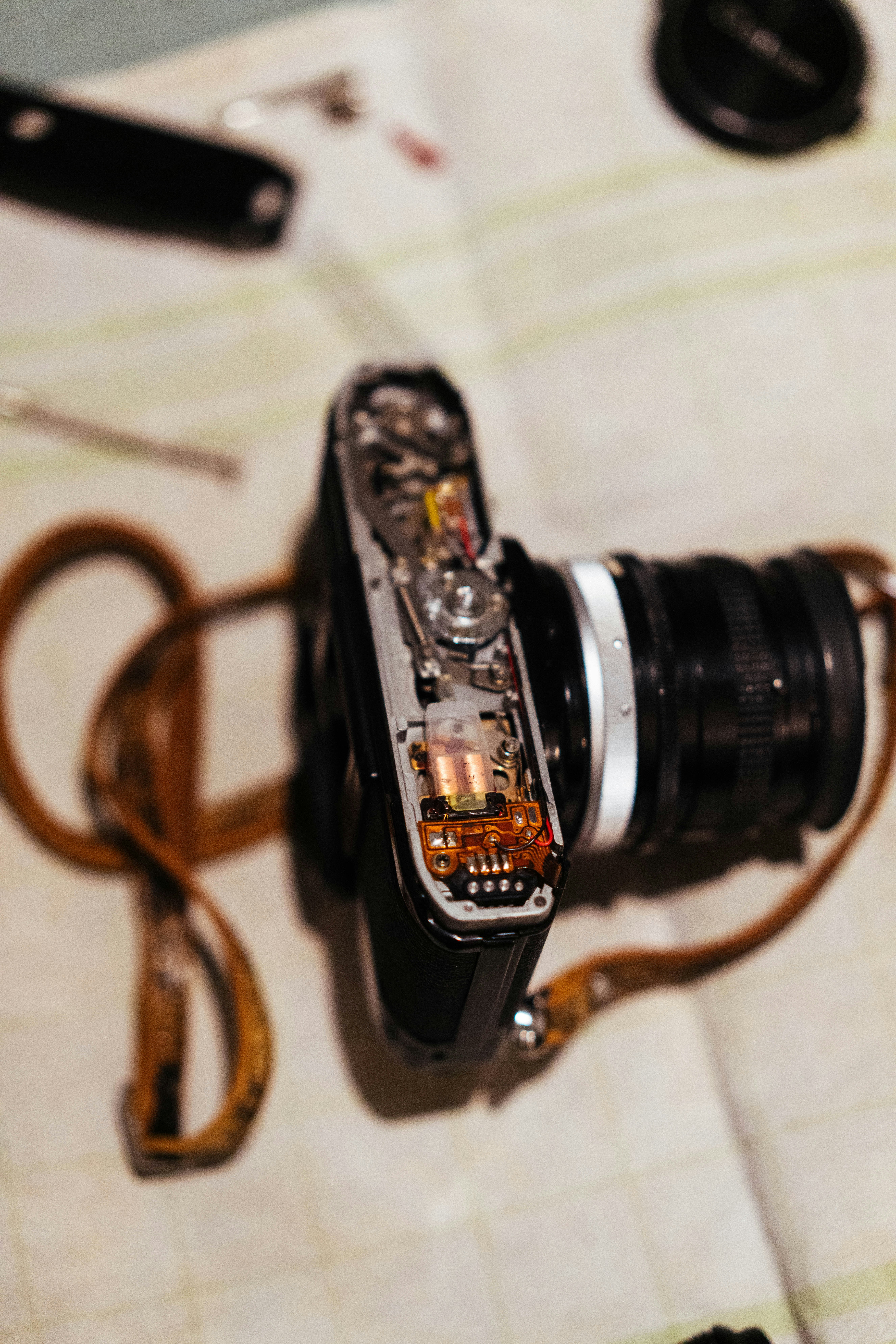Camera disassembled with tools and strap on table