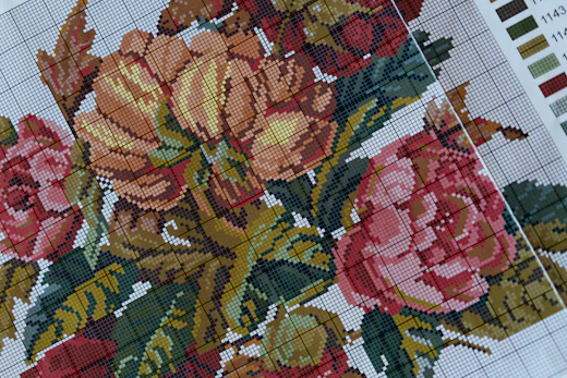 Close-up of a floral cross-stitch on Aida with a color chart
