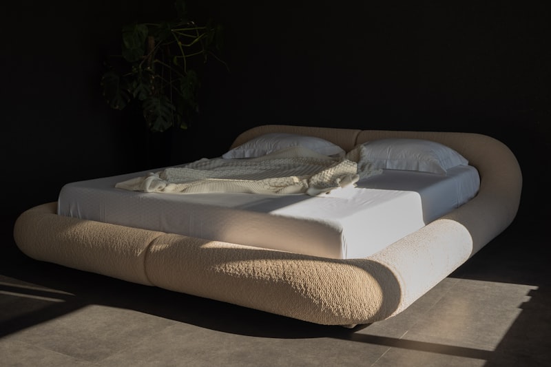 Letto moderno con testiera arrotondata e lenzuola bianche