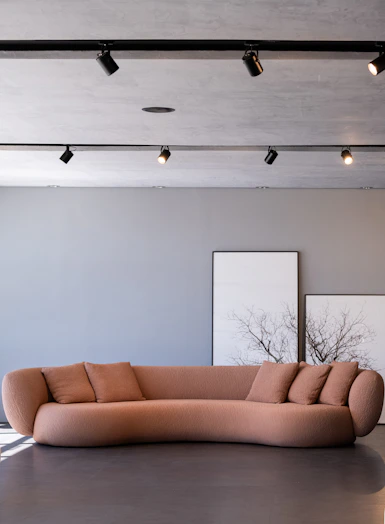 A modern peach sofa with pillows in a room.