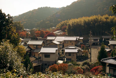 Japanese village nestled among autumn trees and hills.