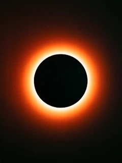 A solar eclipse with a bright orange corona