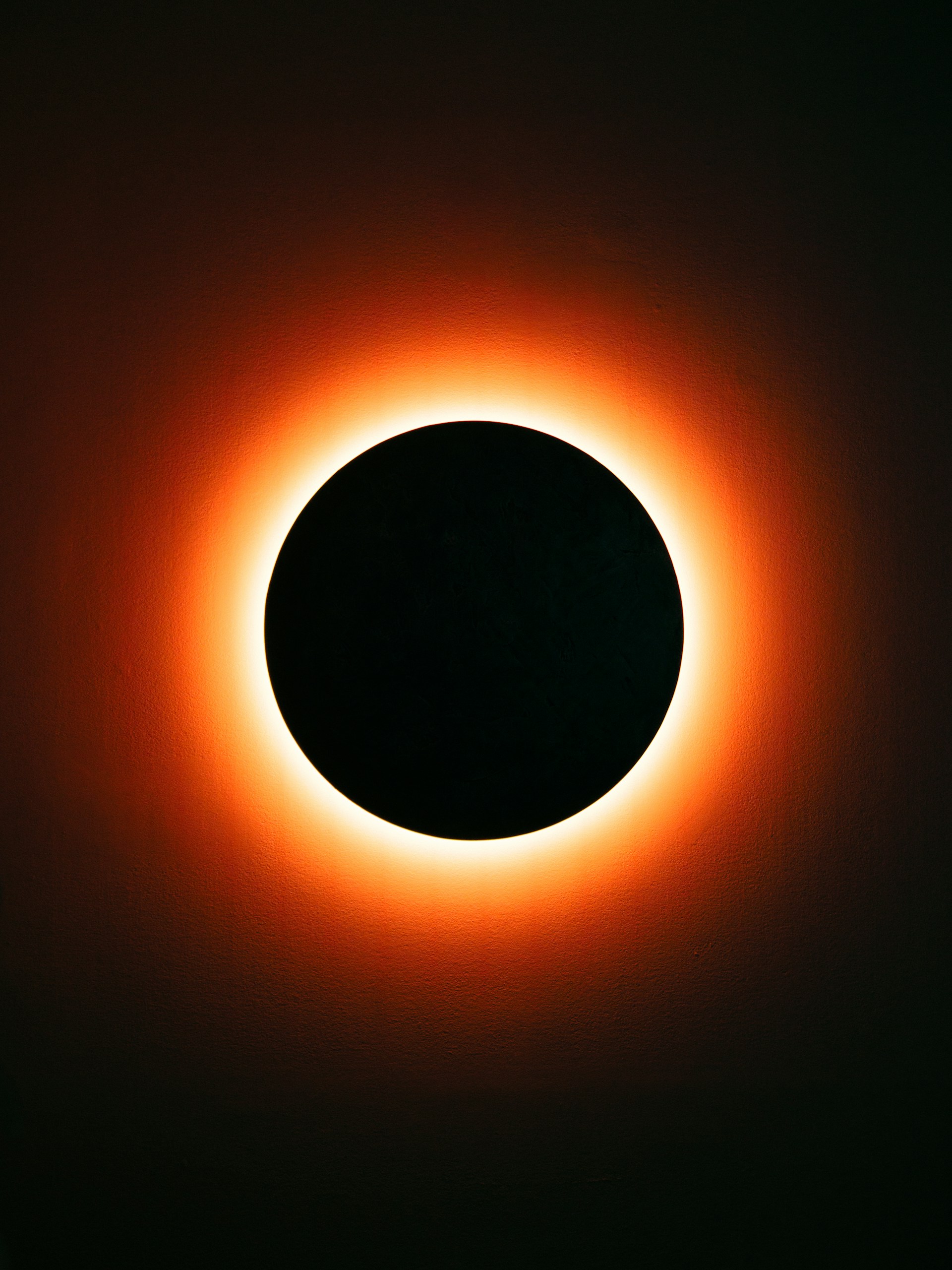 A solar eclipse with a bright orange corona