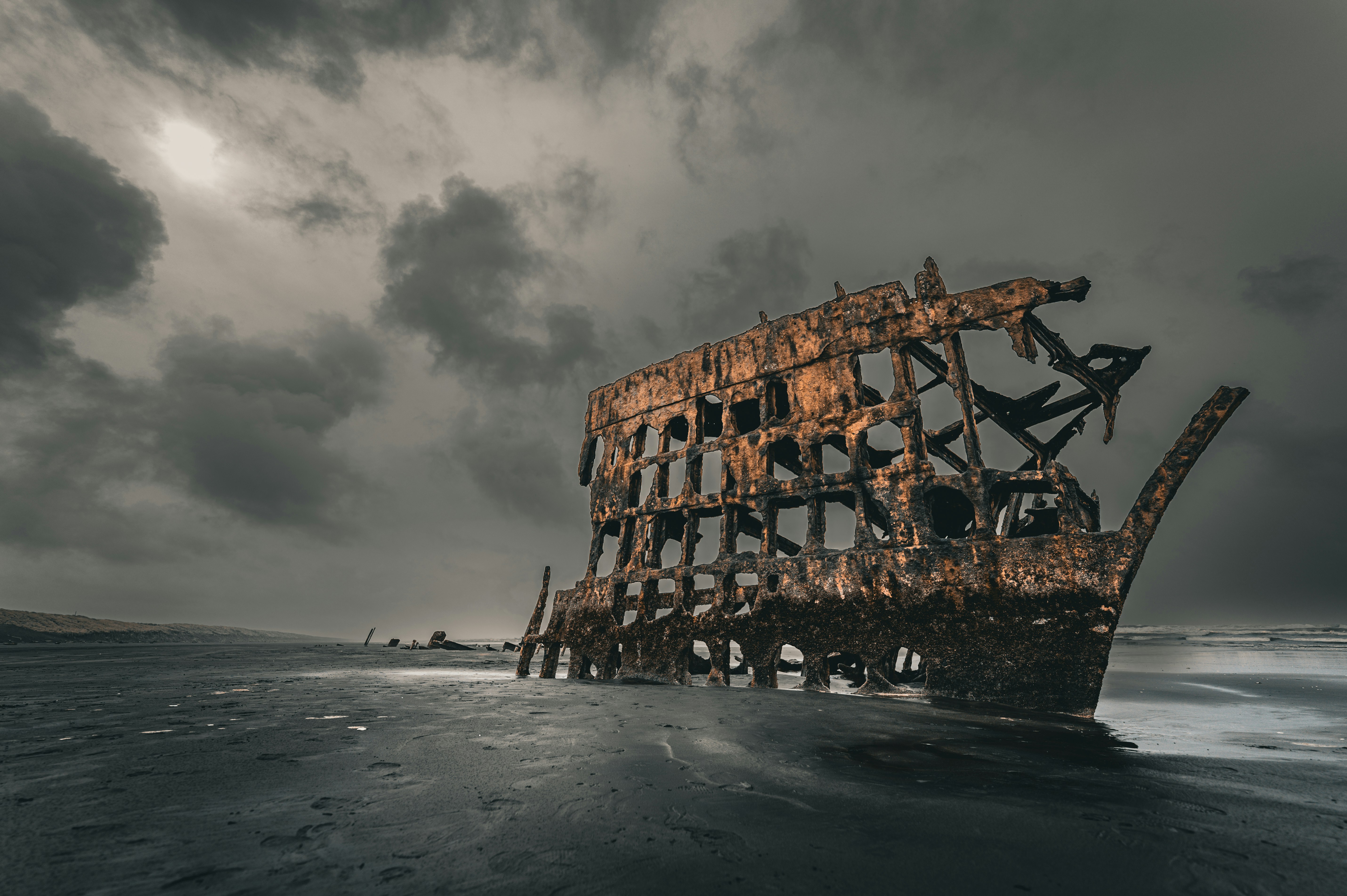 Rusted shipwreck on a dark, stormy beach