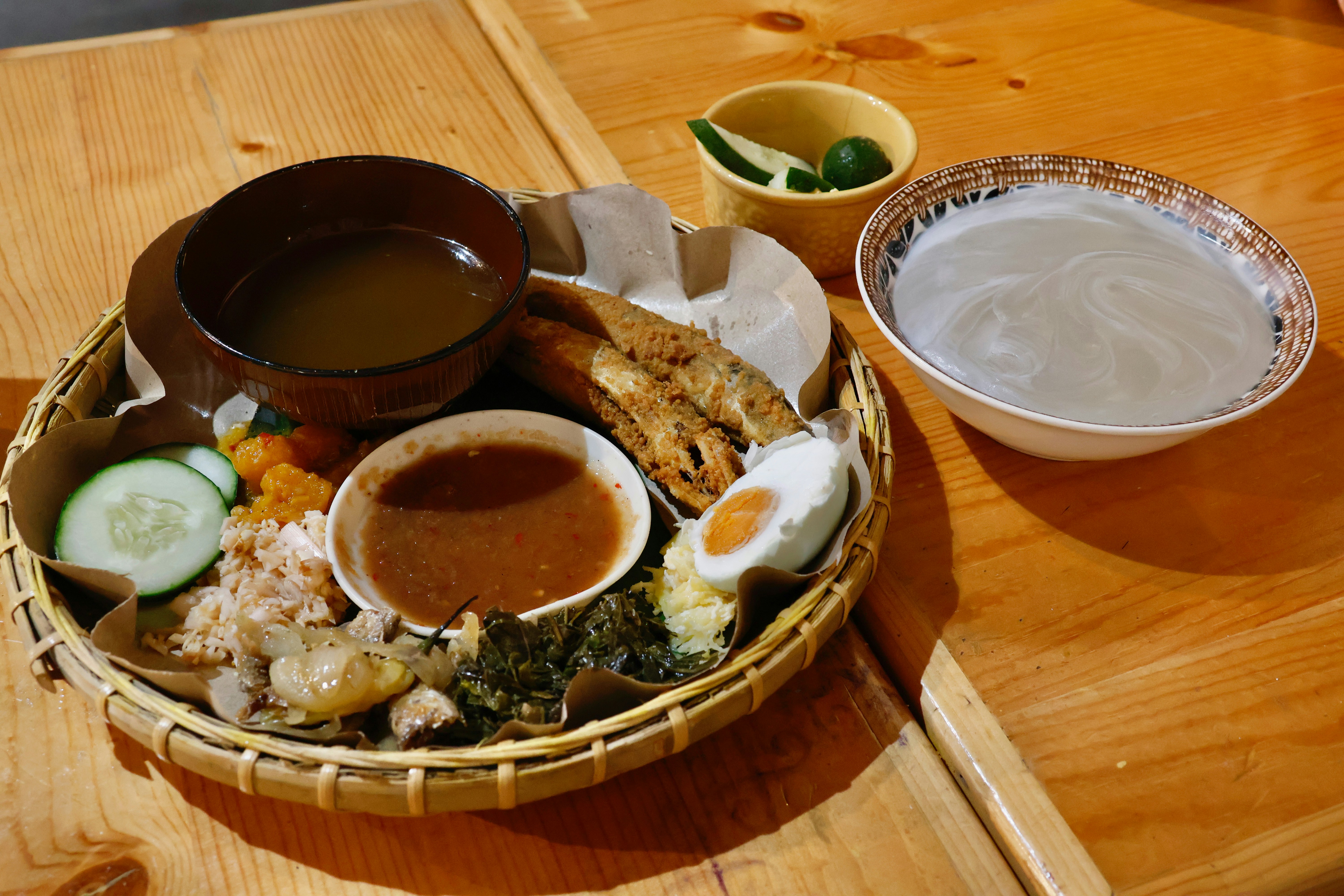 A platter of indonesian food with various side dishes.