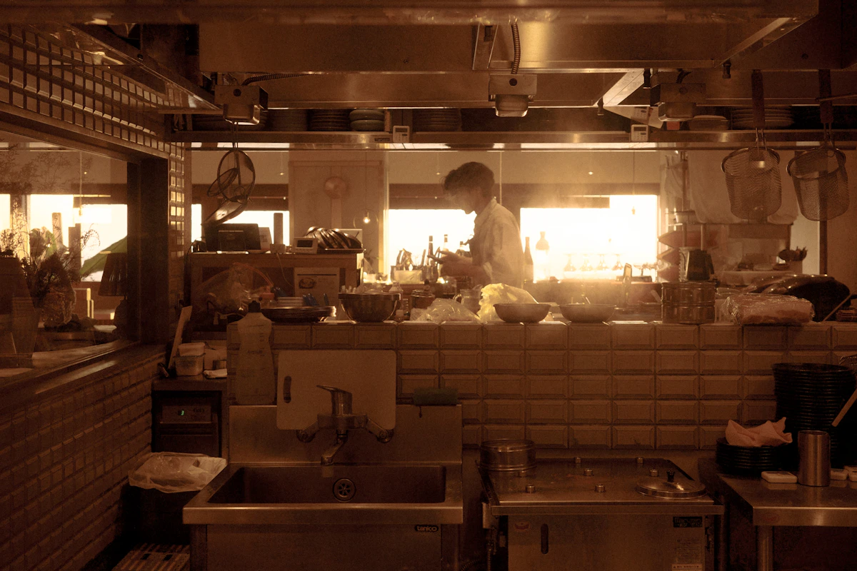 Chef preparing food in a naturally lit kitchen environment