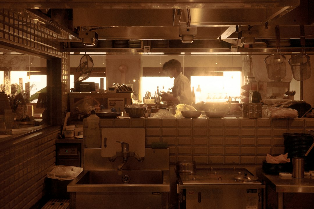 Chef working in a bright, sunlit kitchen.