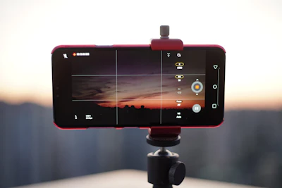 Smartphone on tripod capturing sunset over city skyline