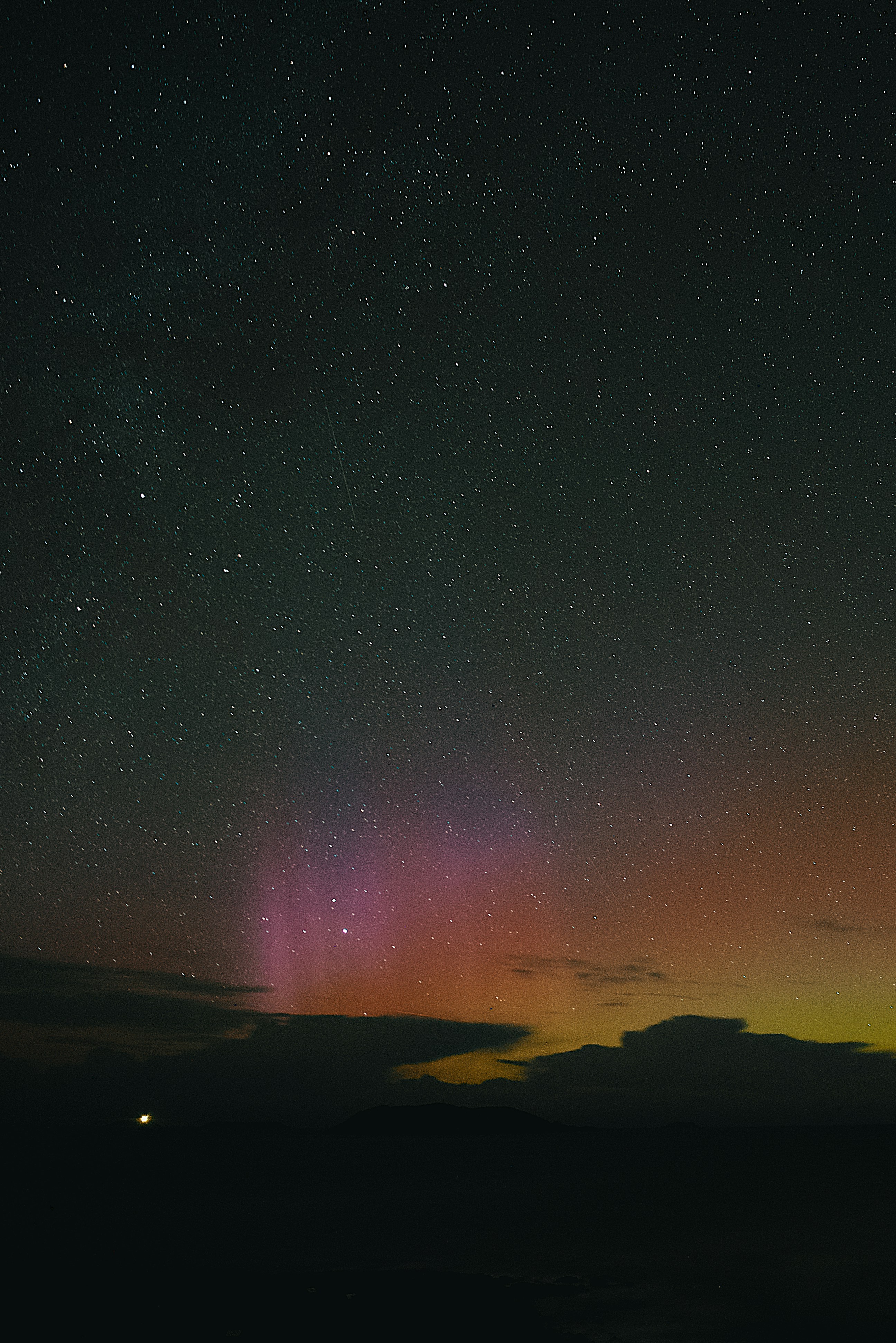 Aurora borealis glows above a dark horizon.