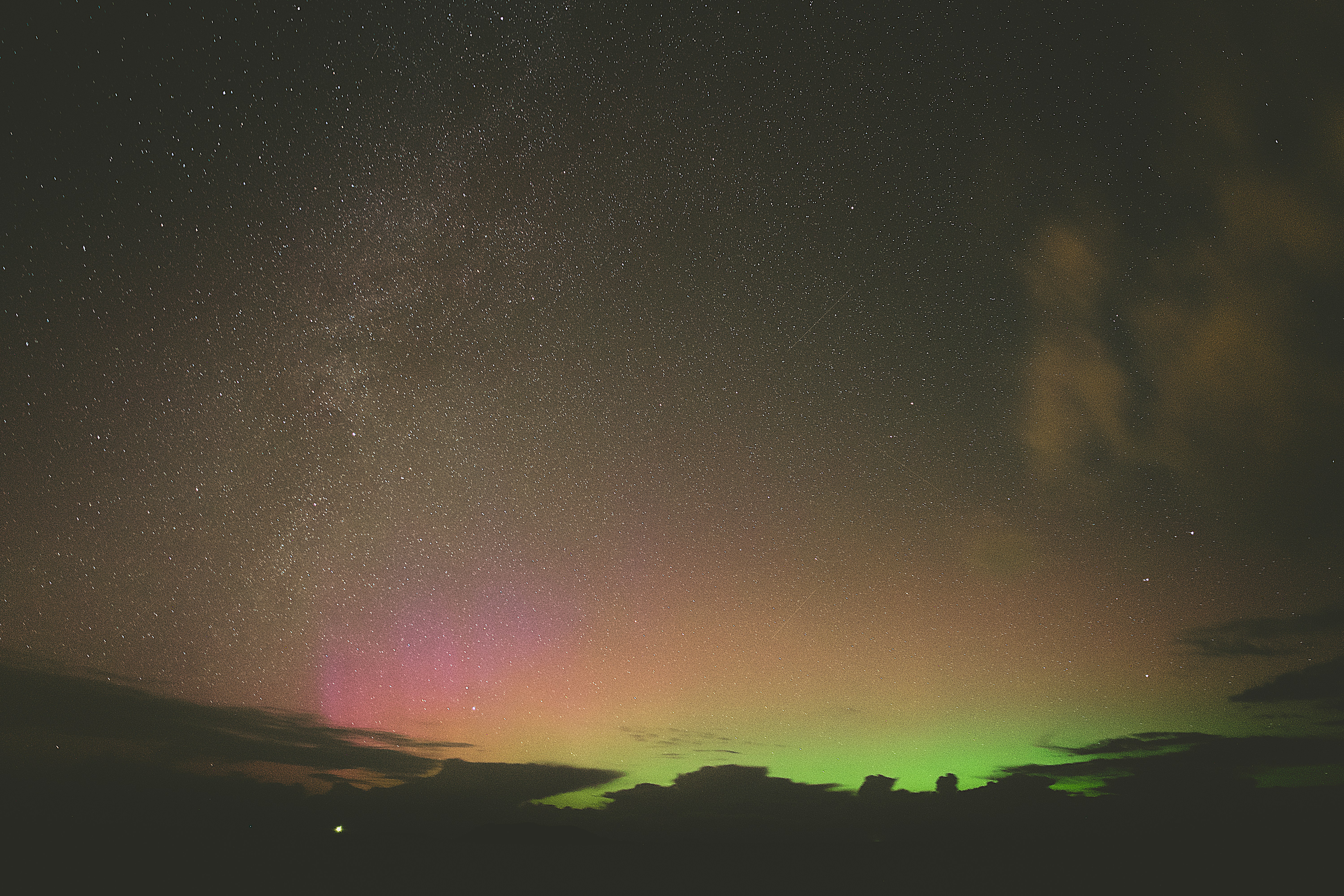 Aurora borealis glows over a dark landscape