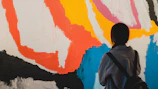 Person looking at a colorful abstract painting