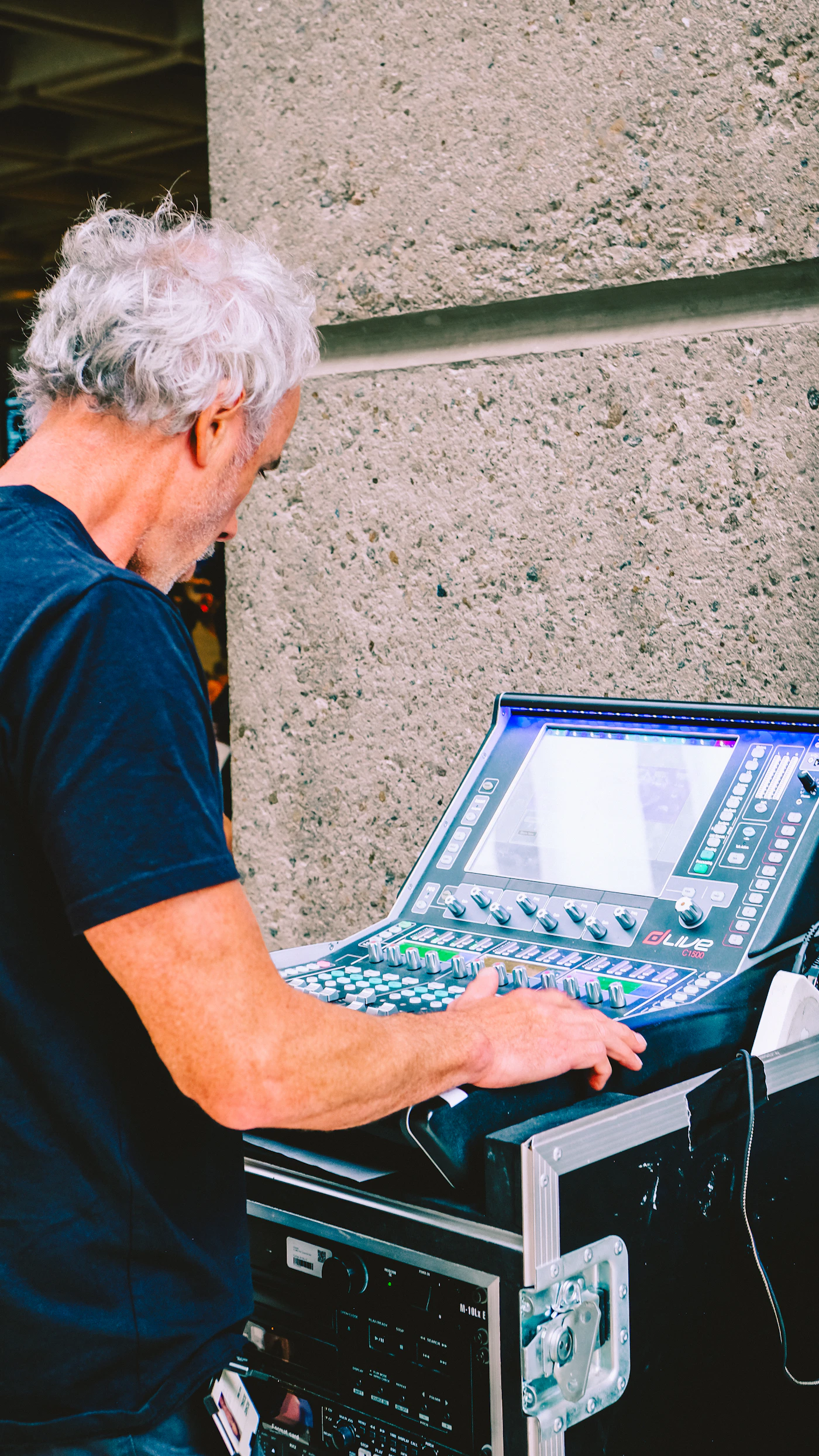 Music producer operating an audio console during a digital production session