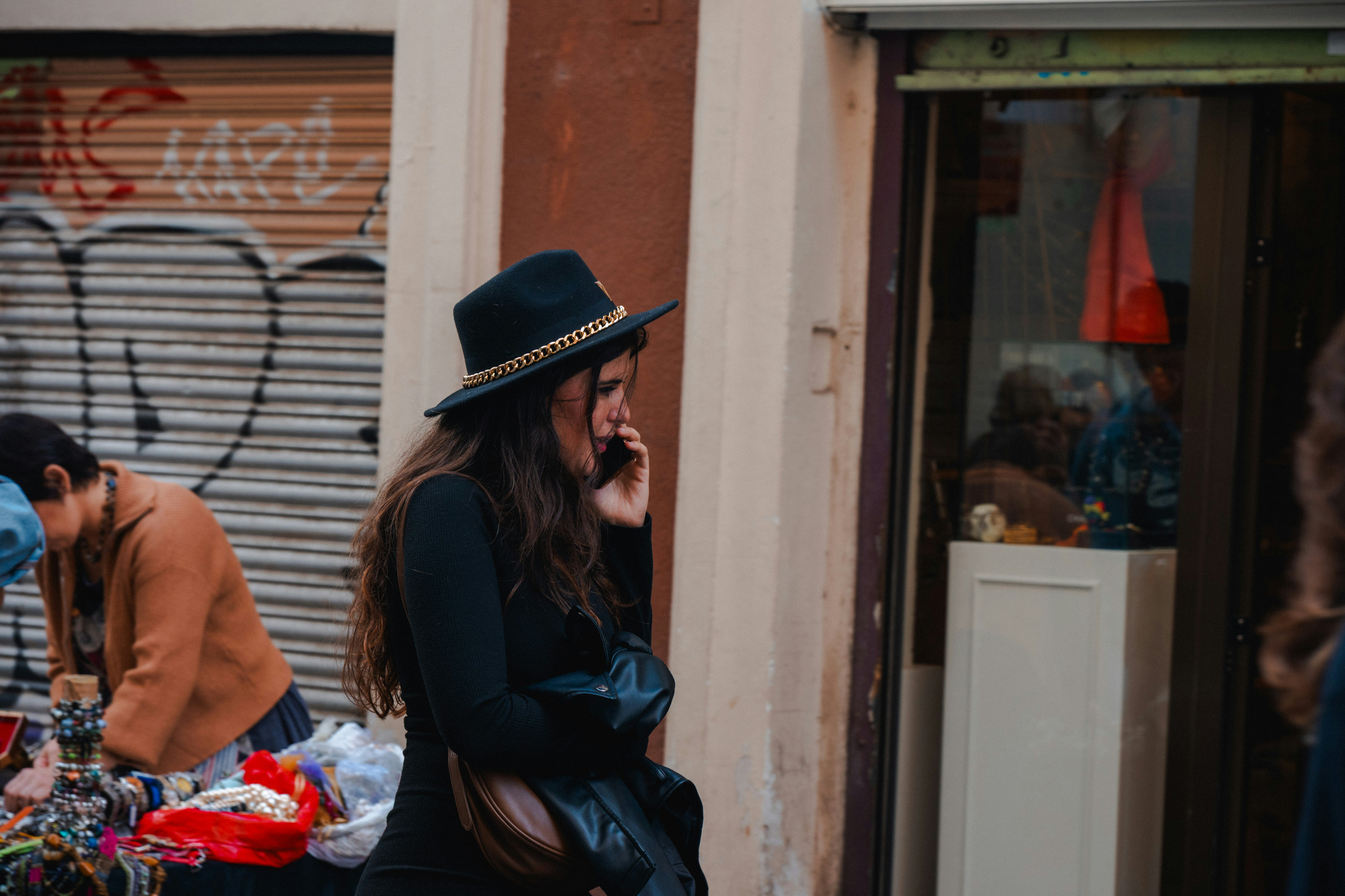 woman in hat on phone on city street