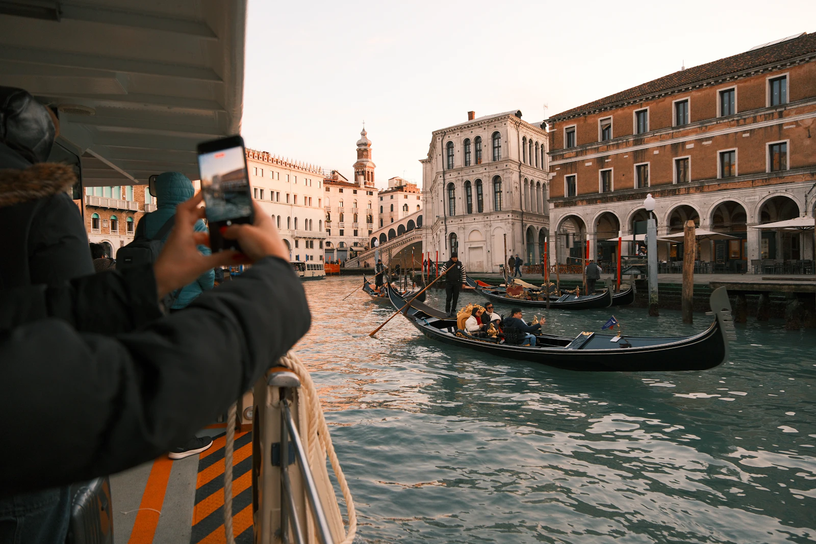 Gondolas on the Grand Canal near the Rialto Bridge seen from a vaporetto at sunset