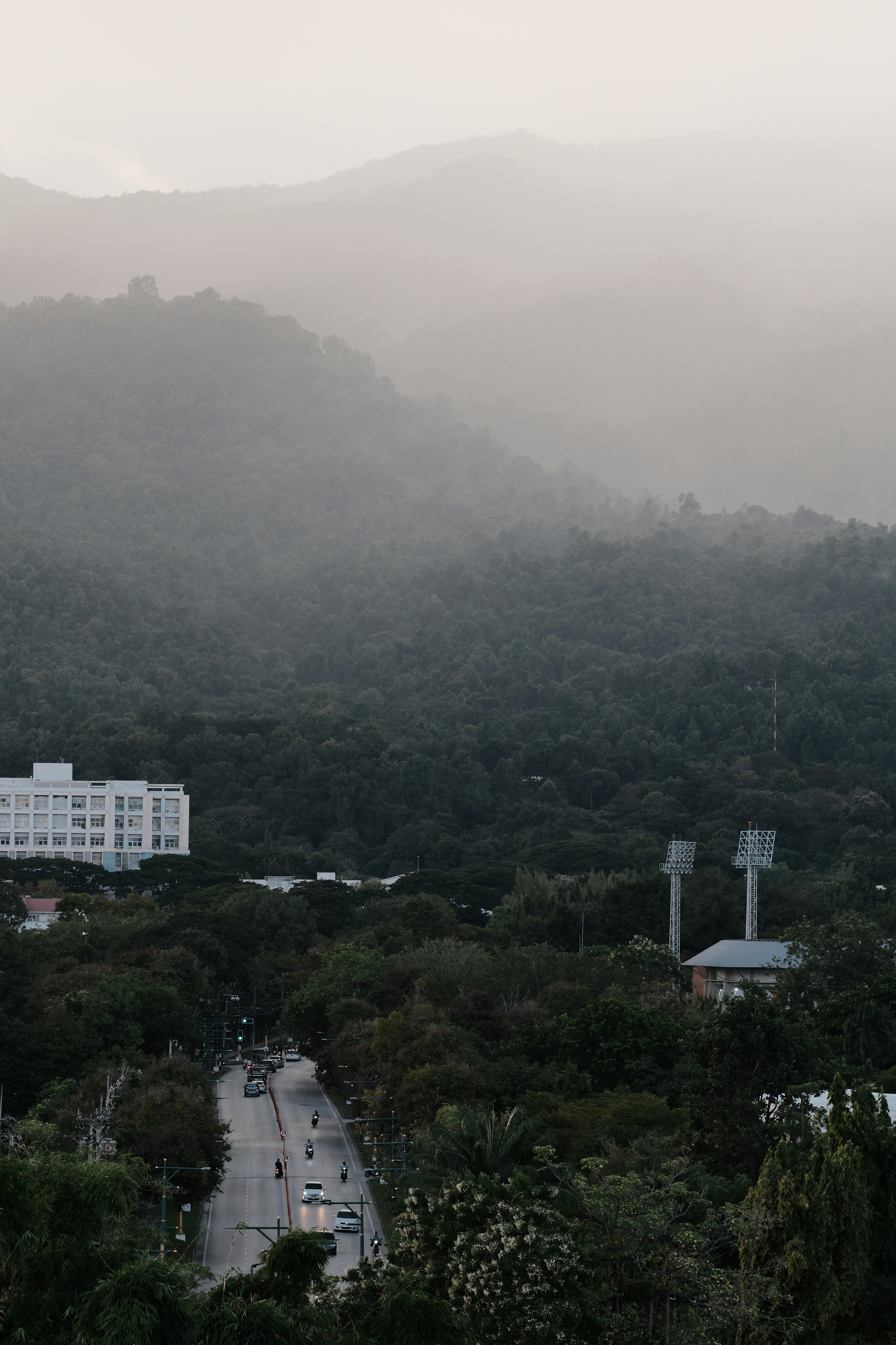 Nebelgebirge überblicken eine Stadt mit einer Straße.
