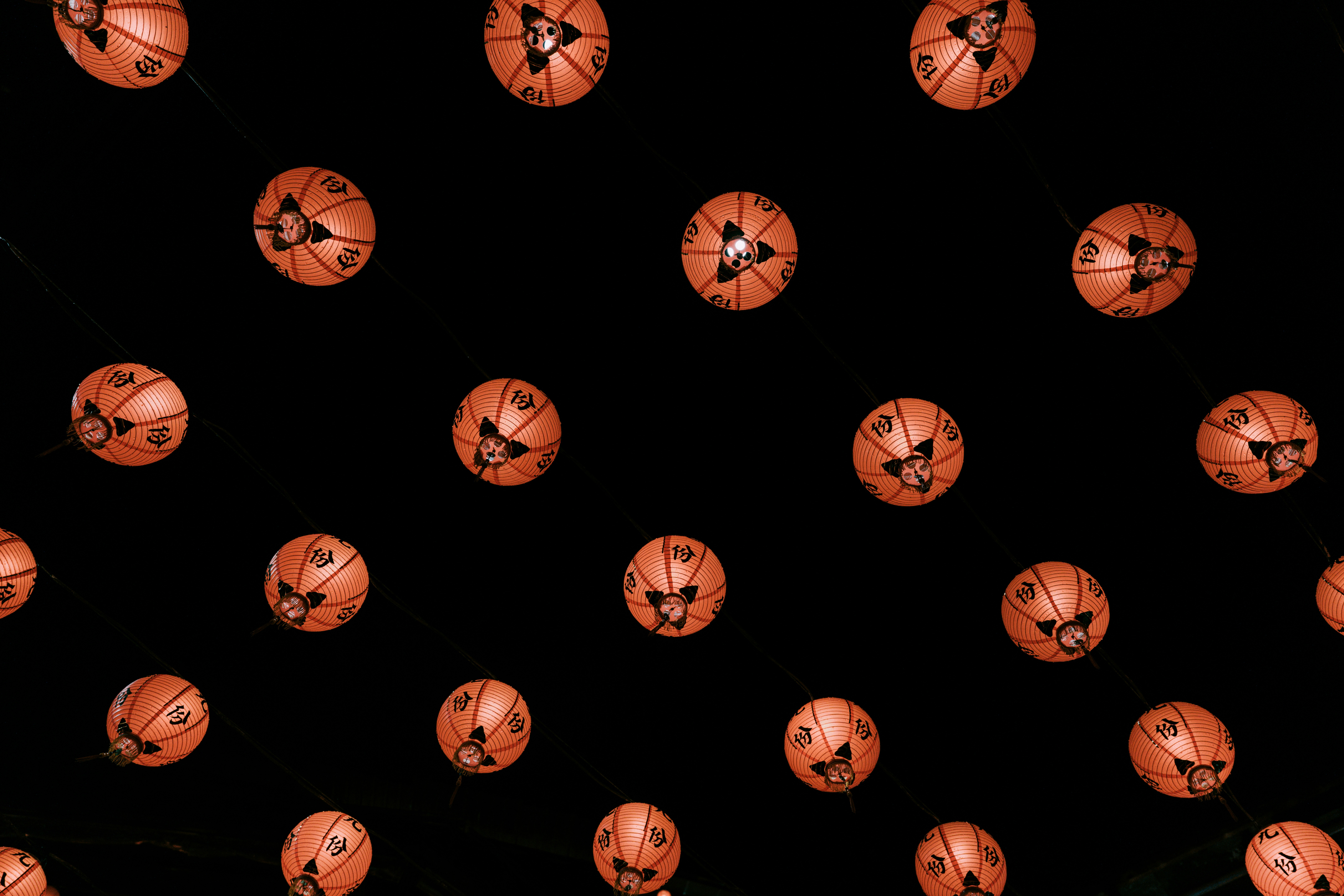 Many jack-o'-lanterns hanging in the dark