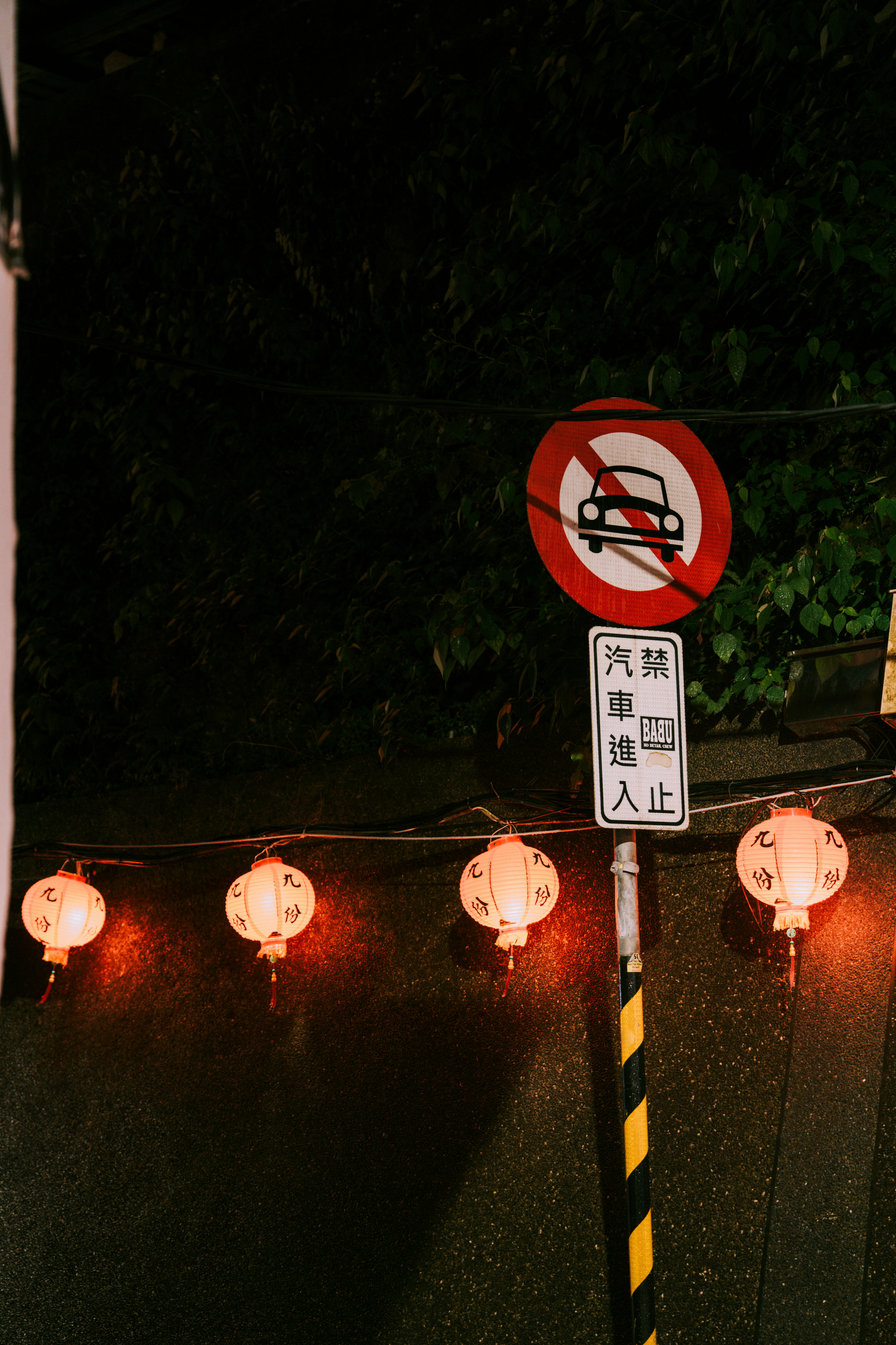 Street sign with lanterns at night