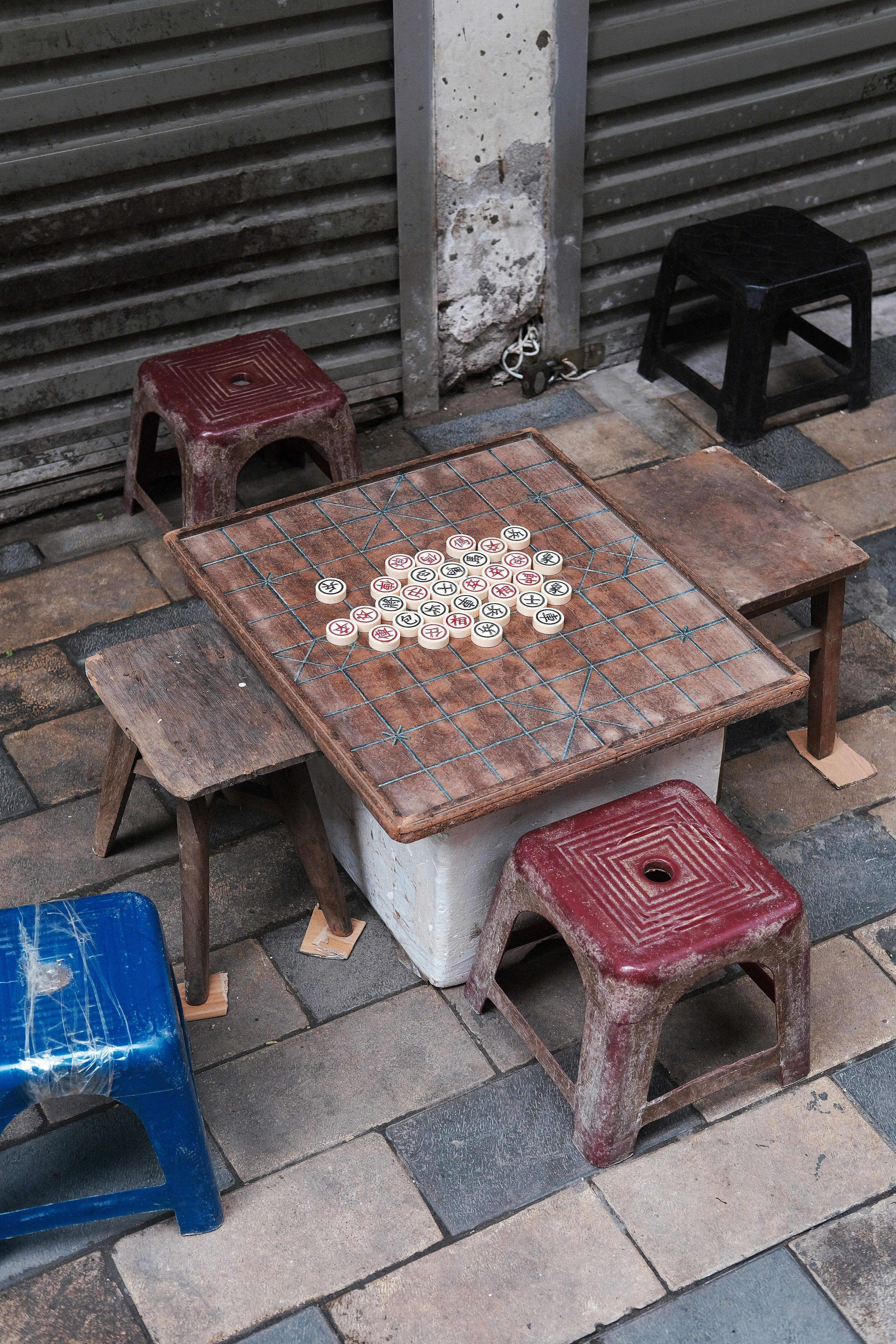 Outdoor table with game pieces and stools