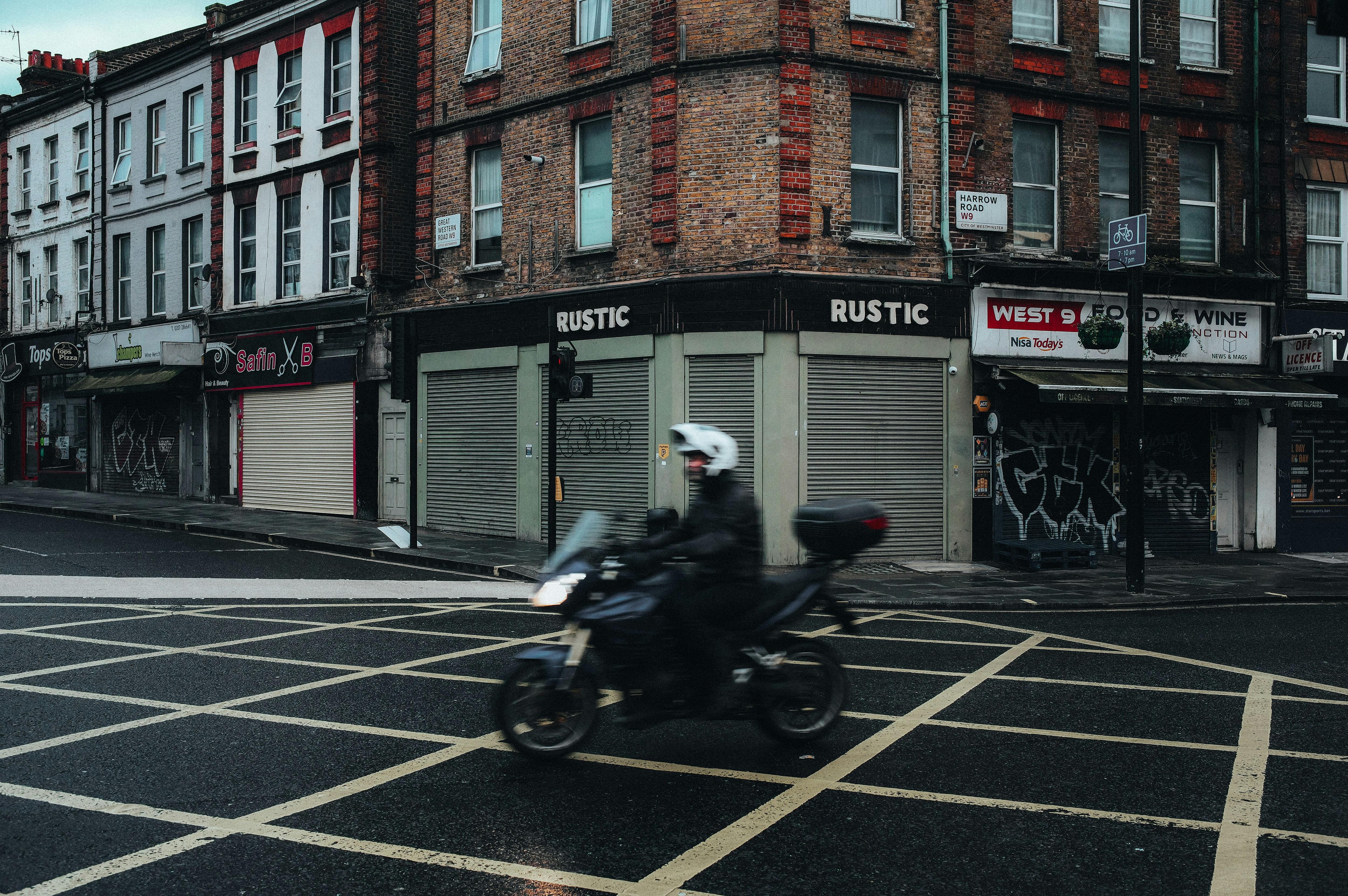 Motorcyclist crosses a street with yellow box junction markings.