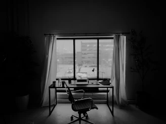 An empty office desk in front of a window.