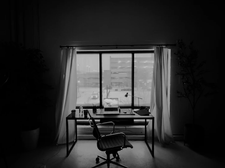 An empty office desk in front of a window.