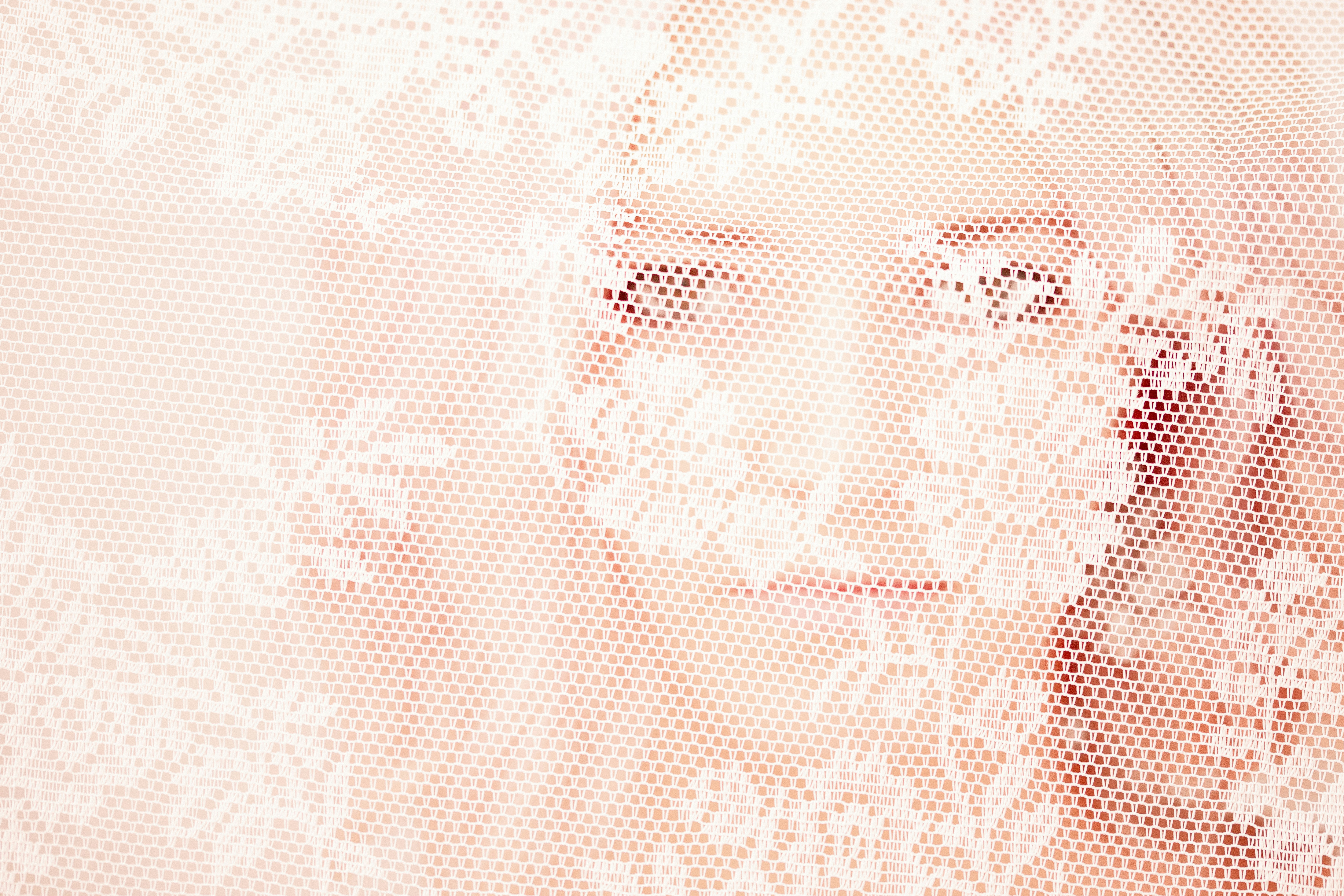 Delicate white floral lace overlay on soft pink background