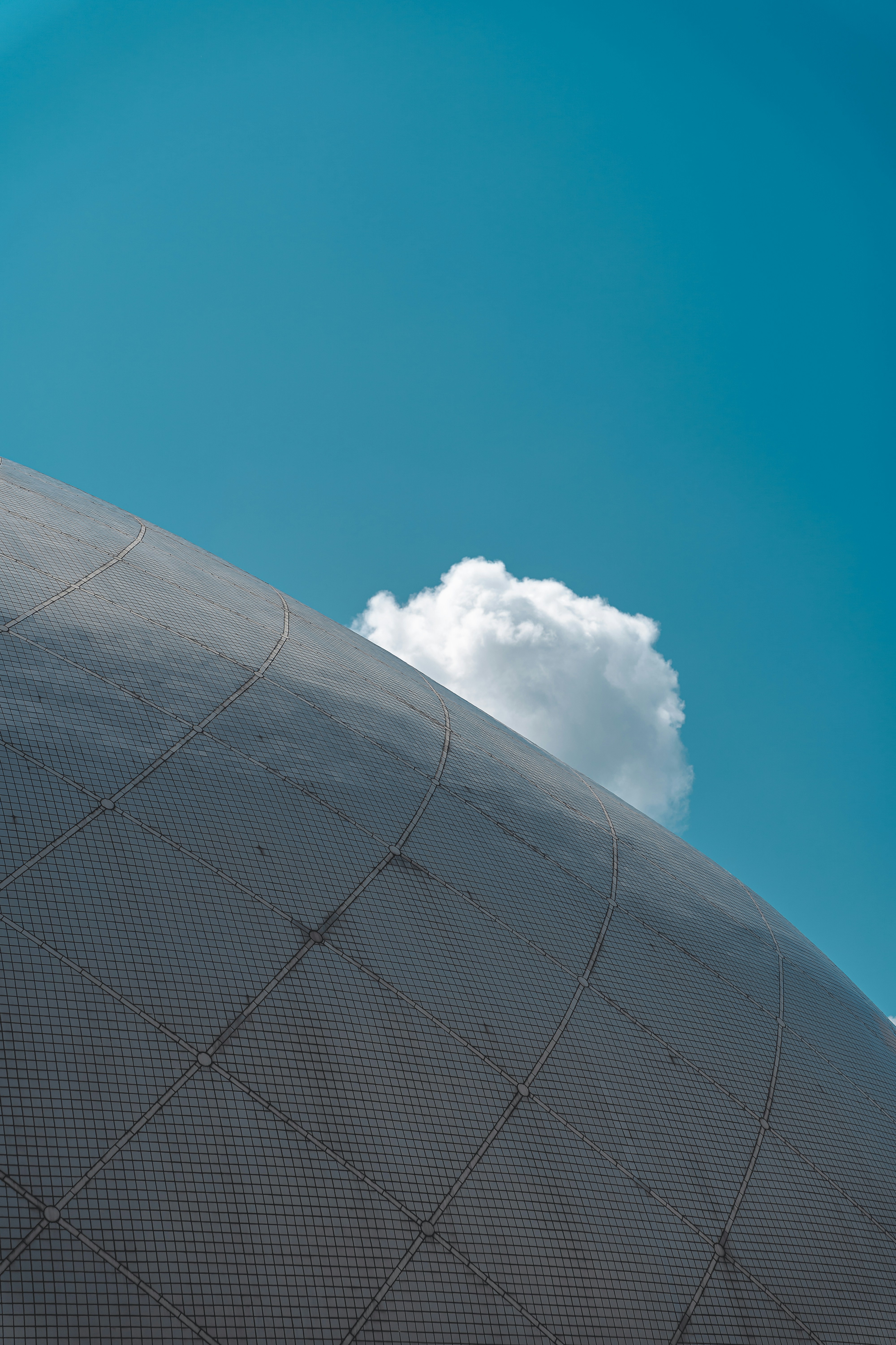 A large white cloud floats against a bright blue sky.